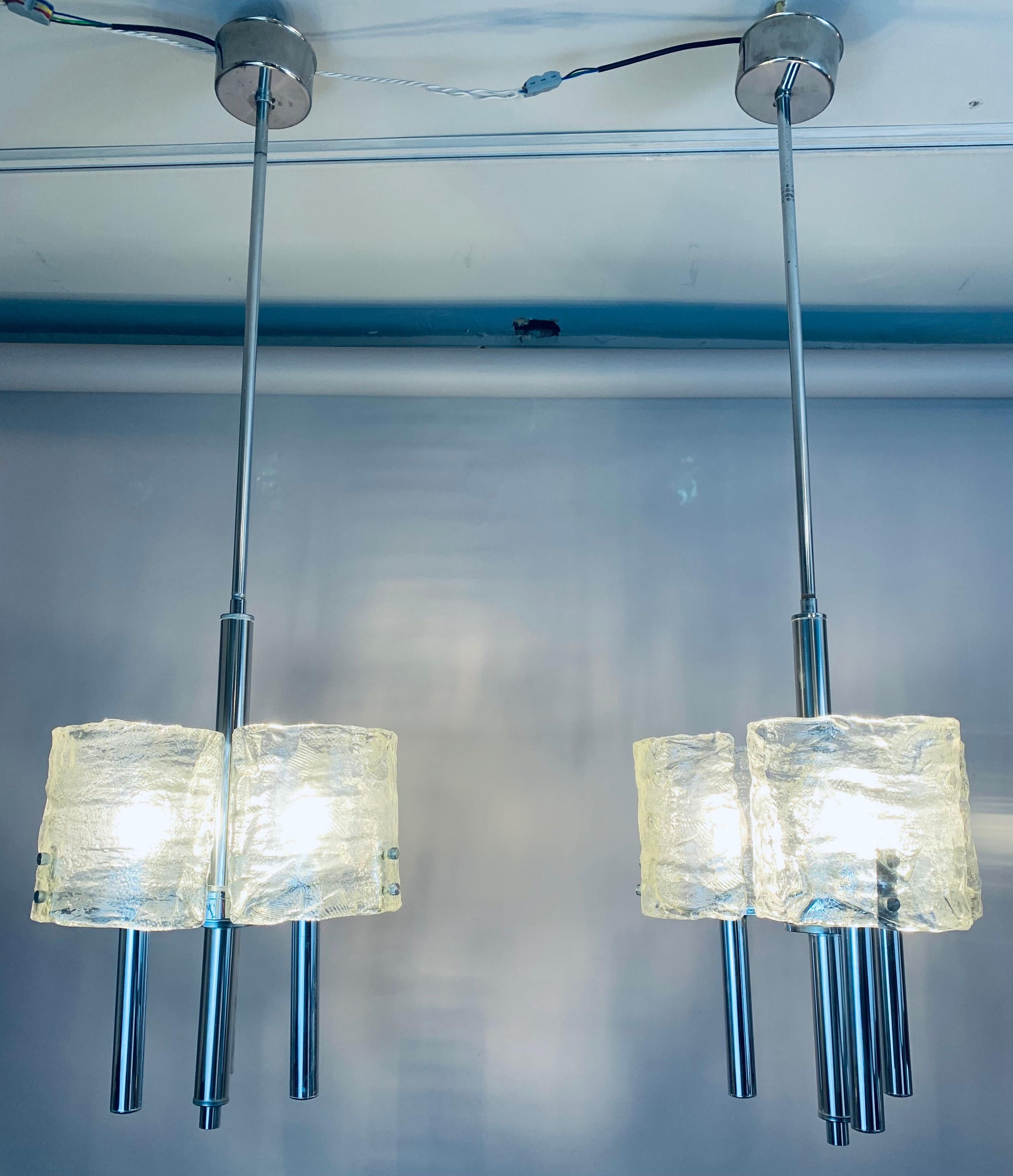 Pair of 1960s Italian polished chromed metal with crescent-shaped Murano glass shades. Designed by Carlo Nason for Mazzega. The three crescent-shaped mottled clear Murano glass shades on each chandelier fit onto the frame with two small feature
