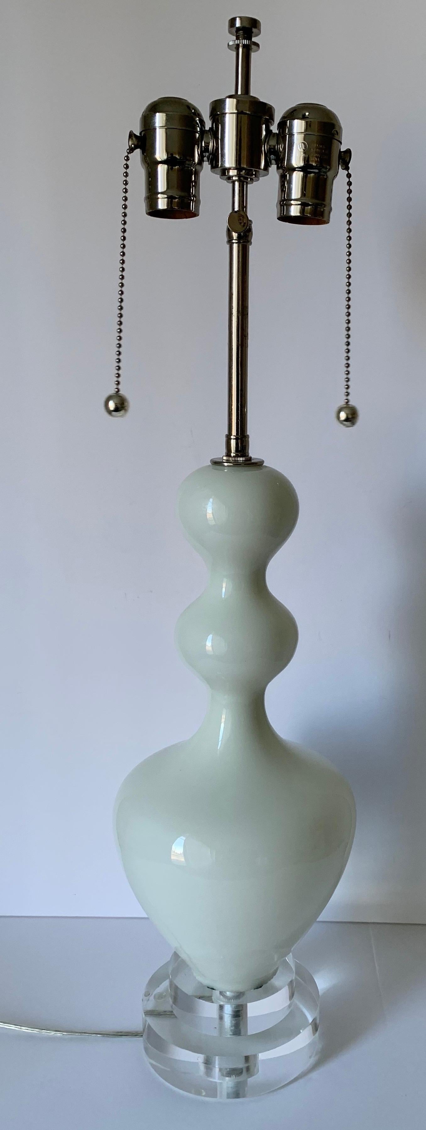 Pair of 1960s Italian white blown glass lamps. Glass is slightly translucent. Newly rewired with nickel fittings and double sockets and side switches. New double stacked Lucite bases. Each lamp takes two standard bulbs (not included). Lampshades not