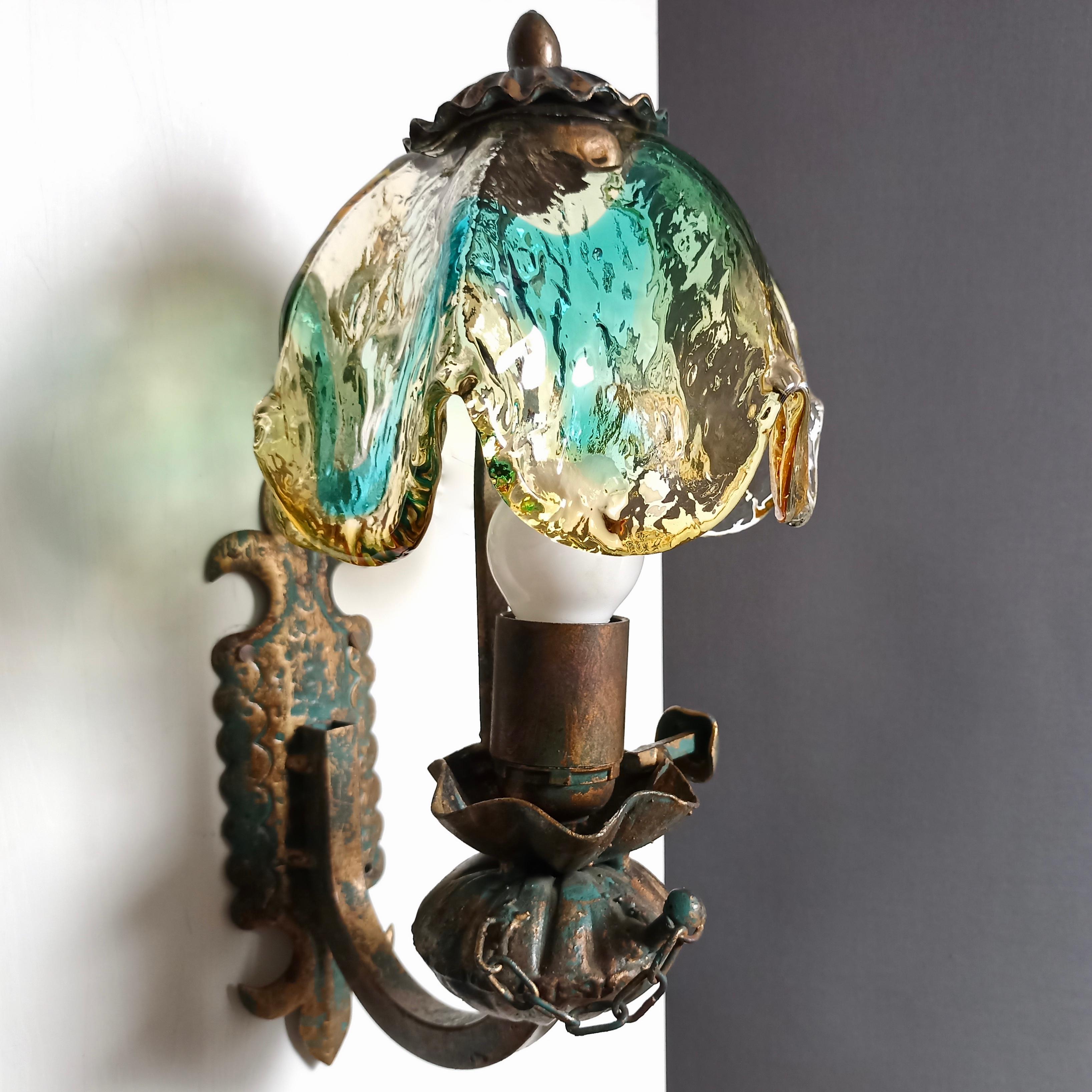Pair of Italian metal sconces with stunning multicolored Murano glass lampshades, made entirely by hand in a small workshop during 1960s taking the shape of old oil lamps as a model. Because of the manual and non-serial workmanship, each of the two