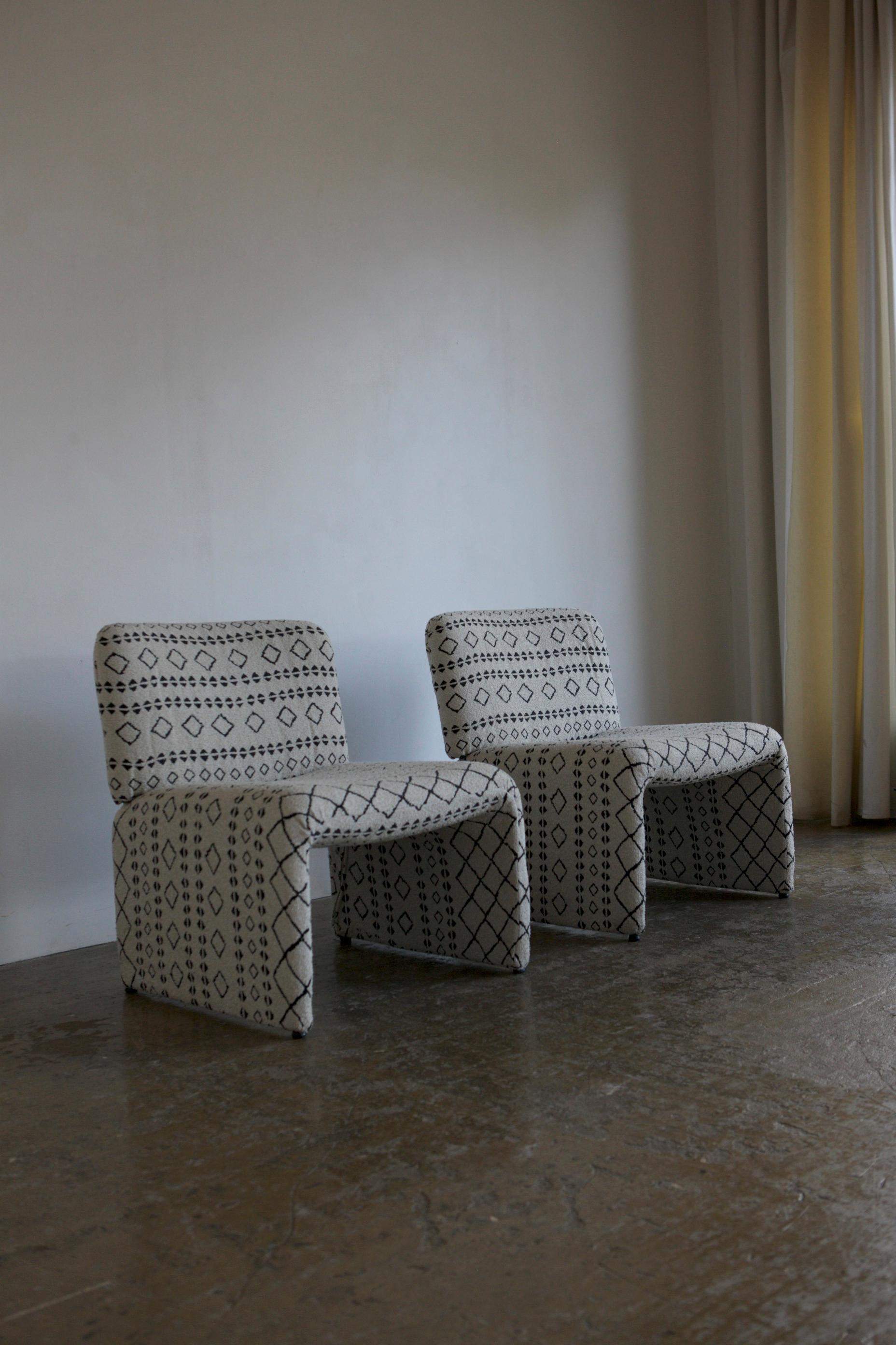 These chairs retain their original 1960's upholstery; a white boucle with a black print woven into it. They are constructed of moulded fibreglass with a foam seat and back rest. Price is for the pair.