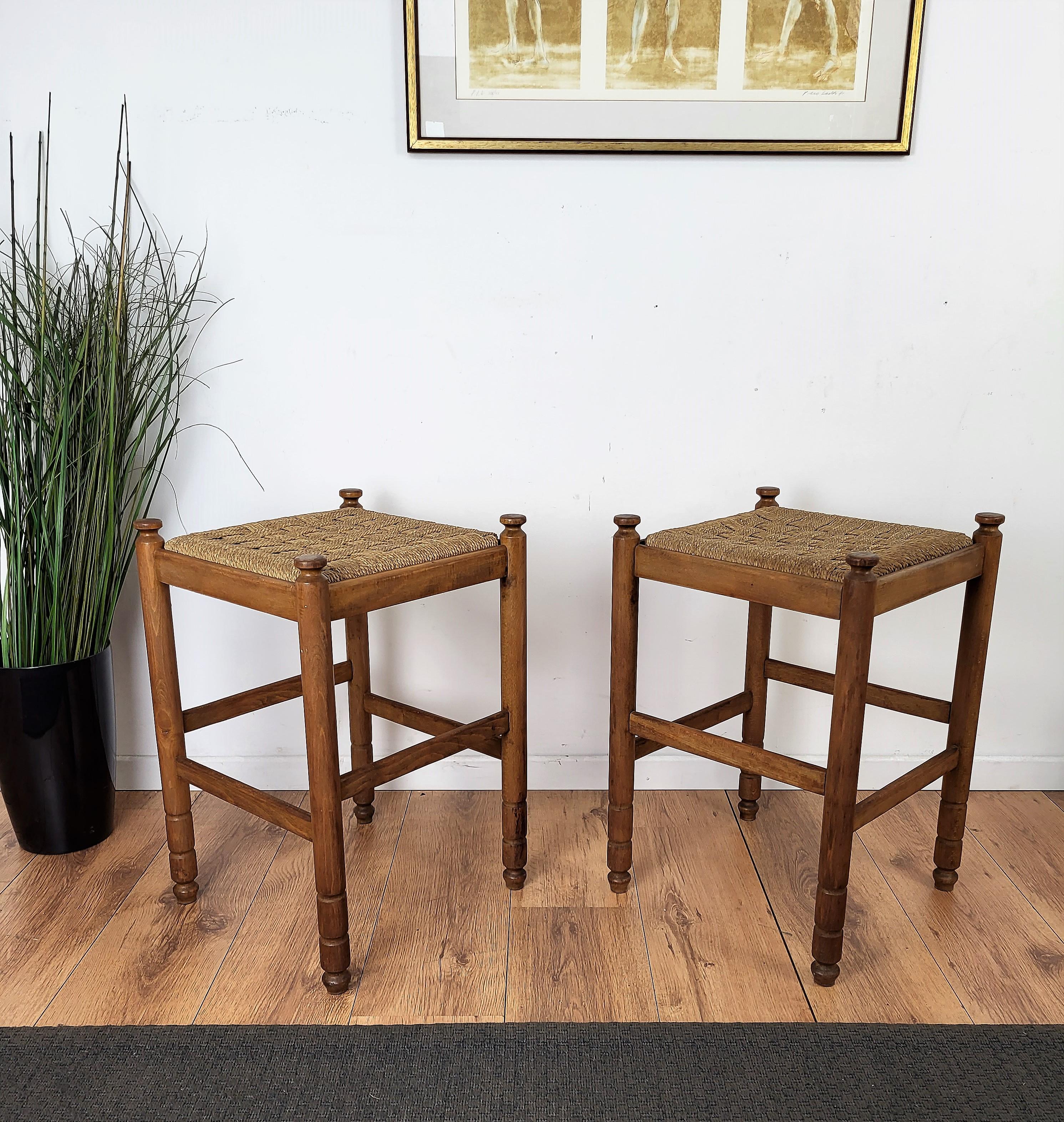 Stylish and beautiful pair of 1960s Mid-Century Modern stools in wood and cord or woven rope, in the style of Audoux Minet with carved decorated legs. The traditional and classical design and shape of the wooden structure, typical of Mid-Century