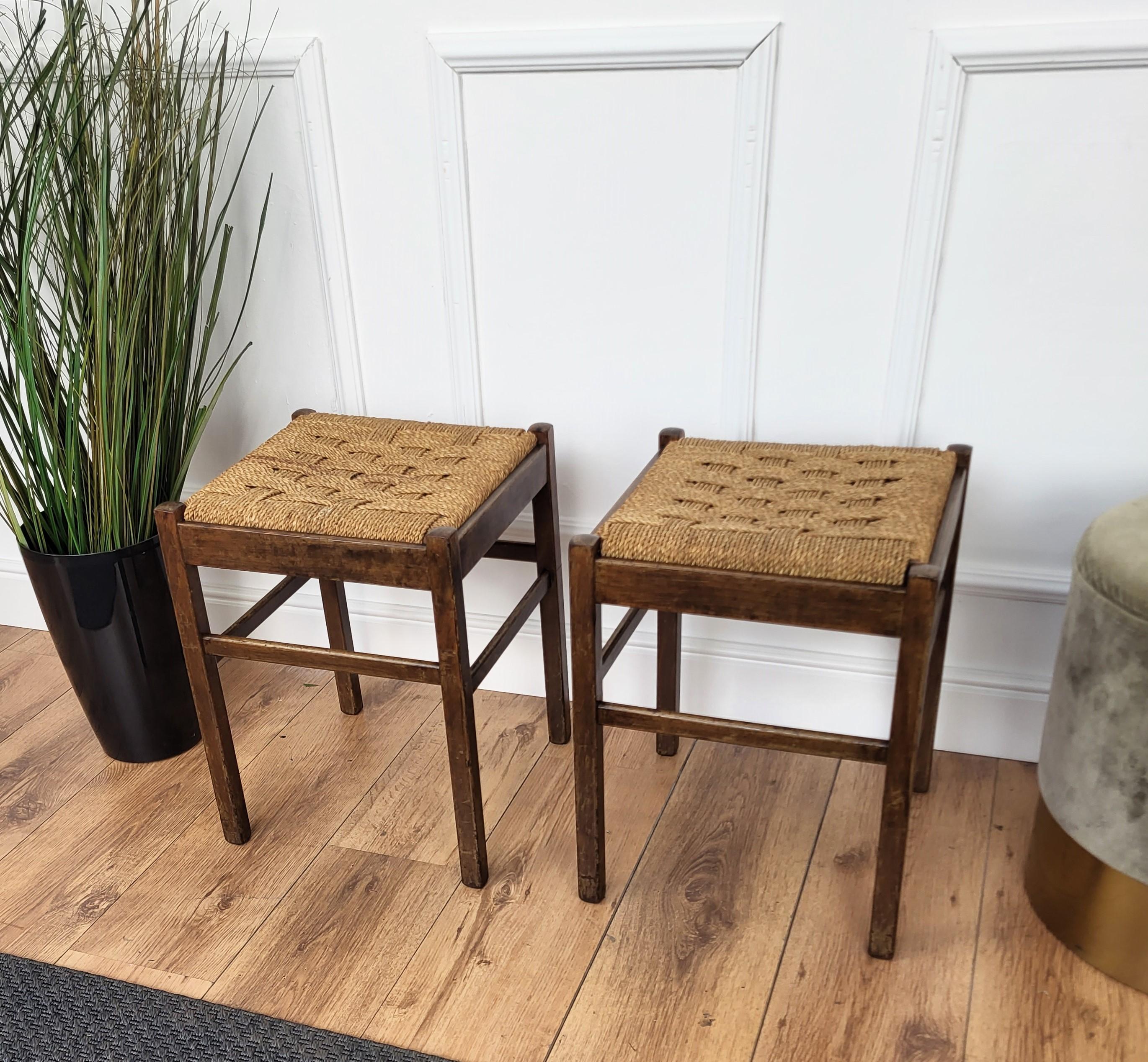 Stylish and beautiful pair of 1960s Mid-Century Modern stools in wood and cord or woven rope, in the style of Audoux Minet with carved decorated legs. The traditional and classical design and shape of the wooden structure, typical of Mid-Century