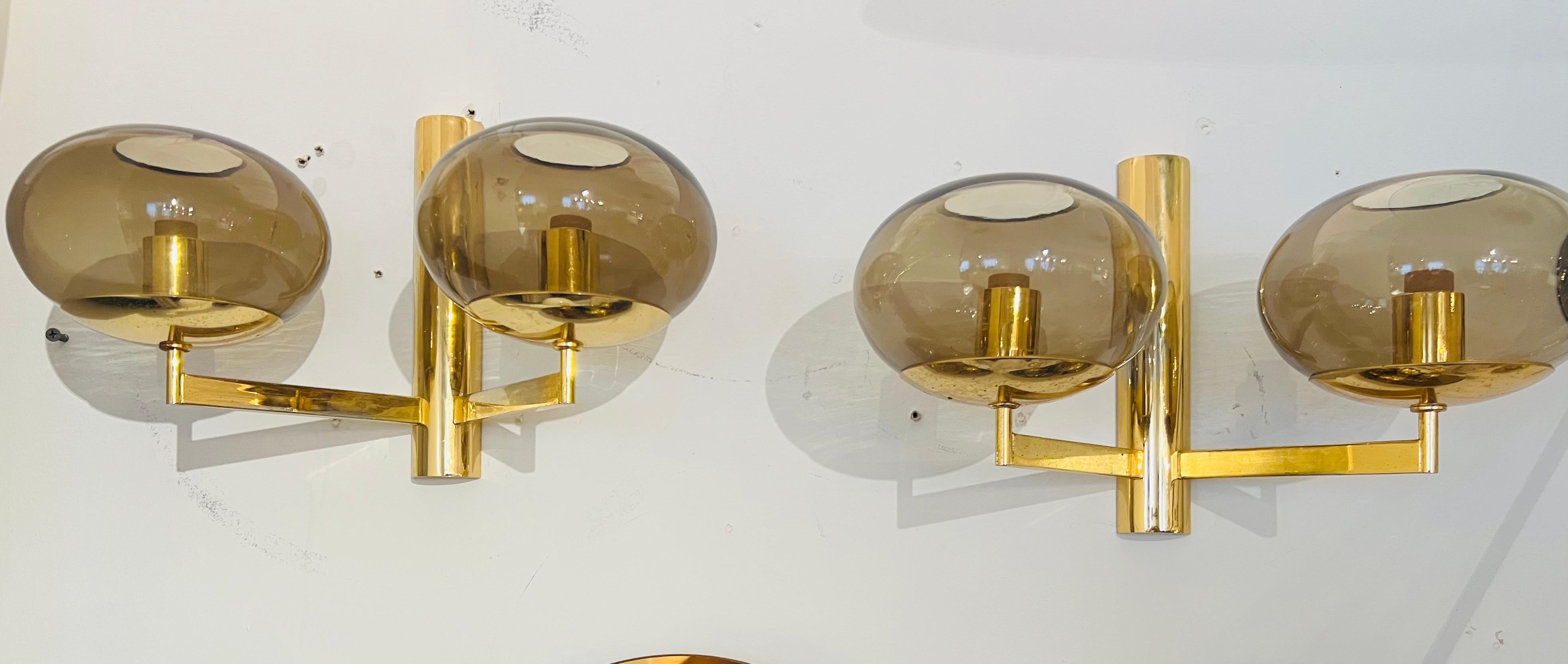 A pair of golden brass double light wall lamps with smoked glass globe shades by the famed Italian lamp maker, Sciolari. Rewired.