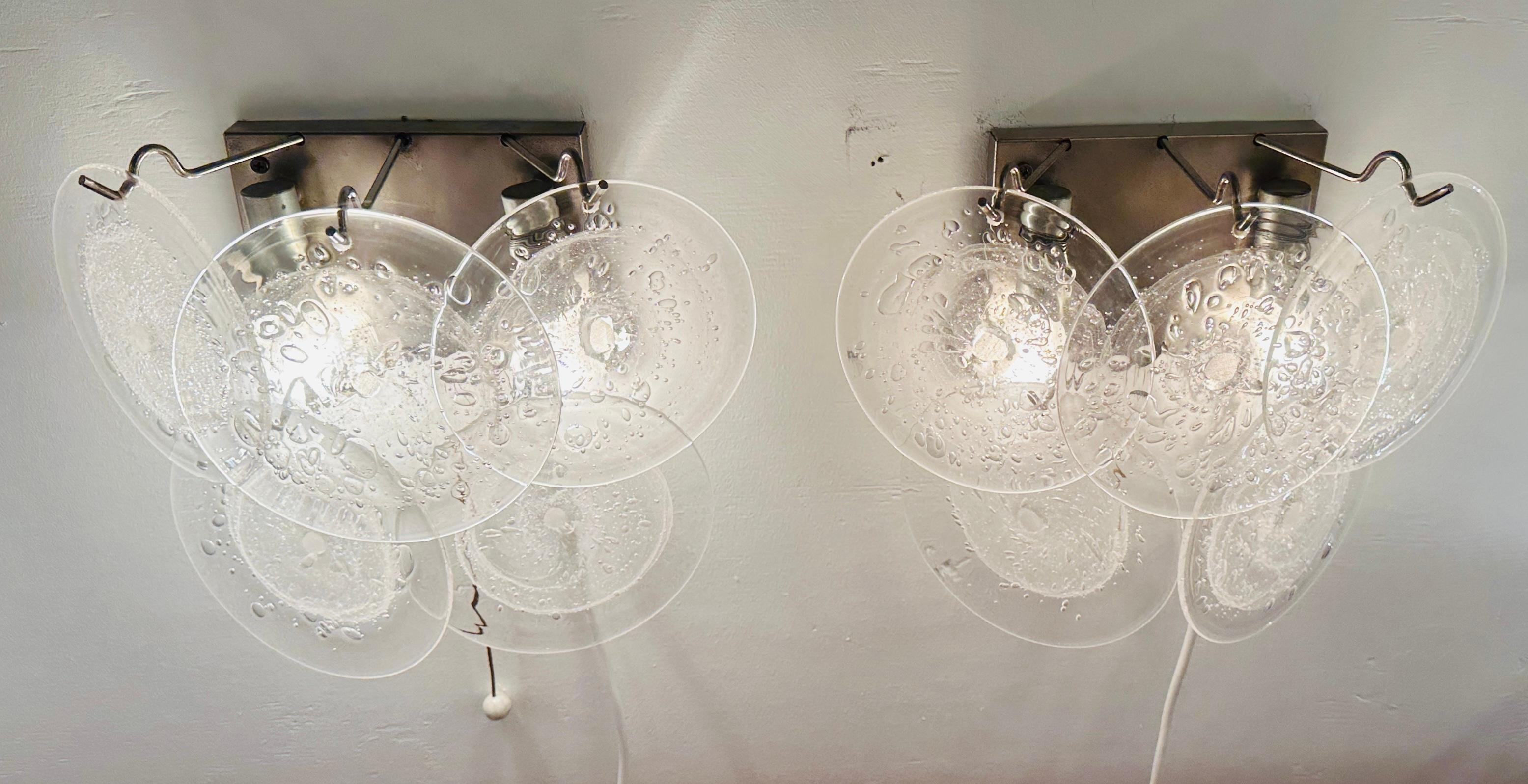 Pair of 1960s Vintage Italian Murano five glass disc wall lights or sconces.  Made in the style of Vistosi.  The textured glass round discs are frosted white in the centre  to help to disguise the two lightbulbs sitting behind but clear around the
