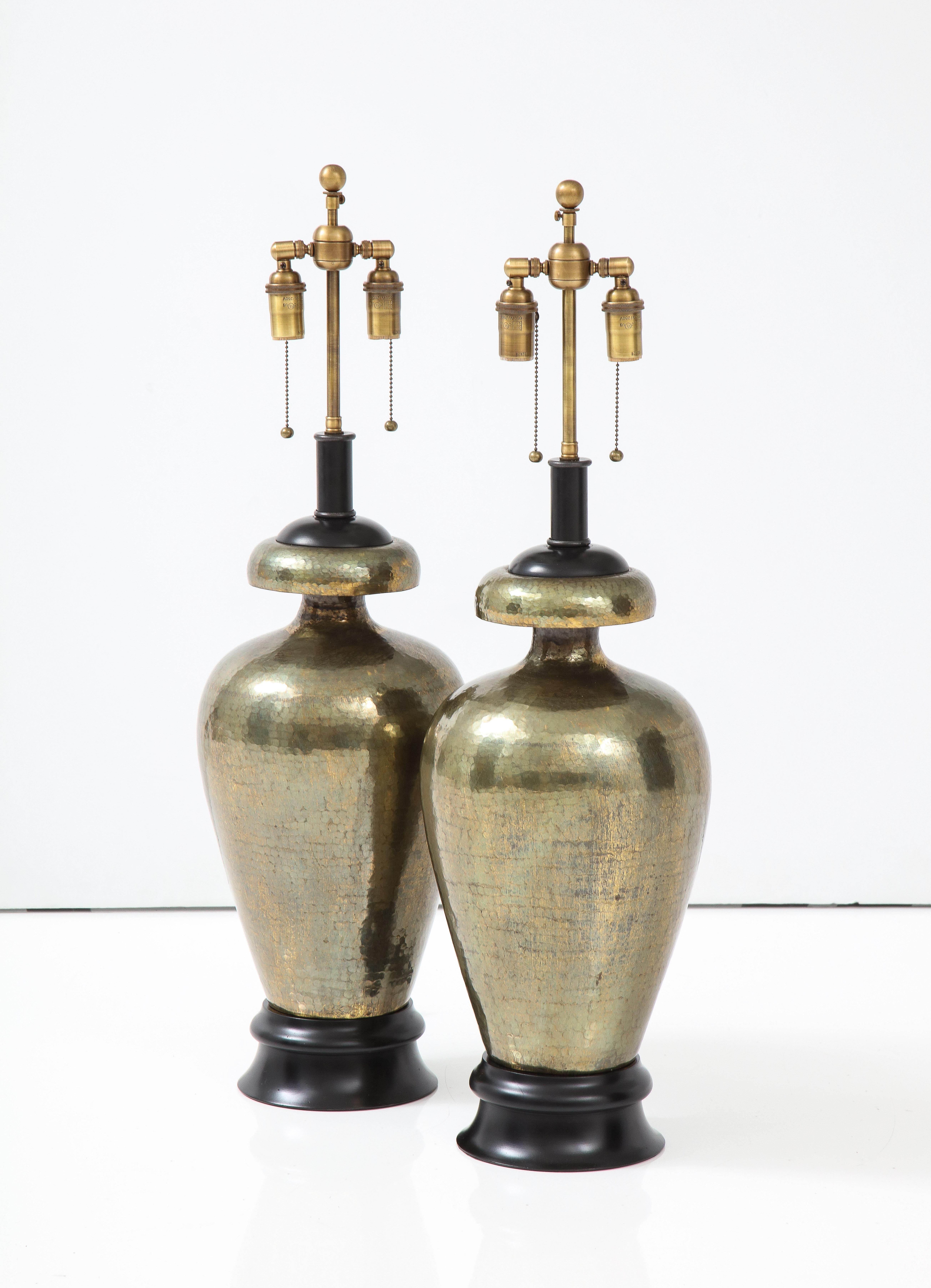 Pair of 1960's large Hammered brass lamps.
The hammered brass lamps have a wonderful patina and they have been
Newly rewired with adjustable Antique brass double clusters that take standard size bulbs.
The height to the top of the brass lamp is 21