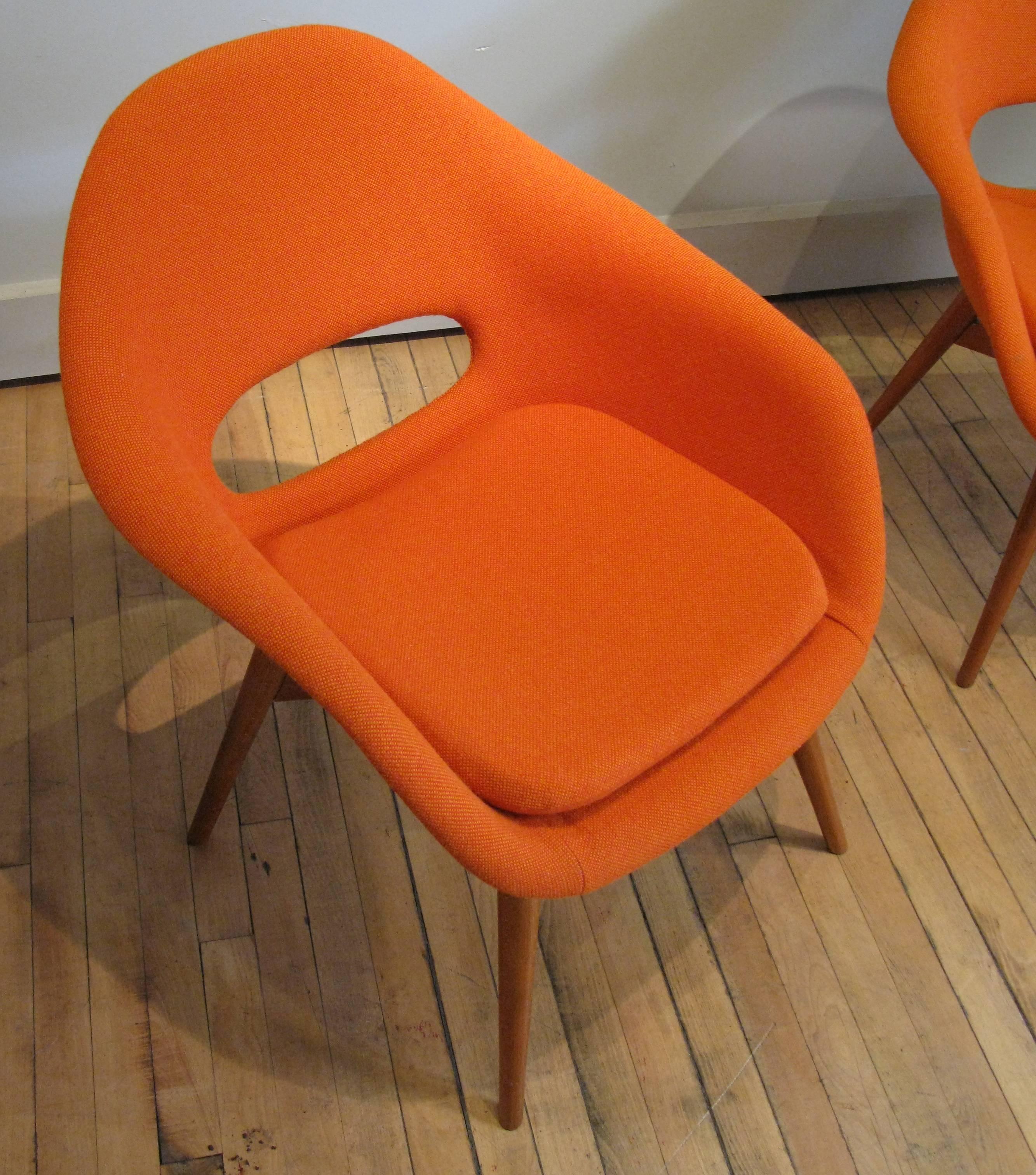 A beautiful, stylish and comfortable pair of 1960s lounge chairs with birch bases designed by Miroslav Navratil. Great design with an open cut out in the back, these have been reupholstered in an orange Kravat fabric.