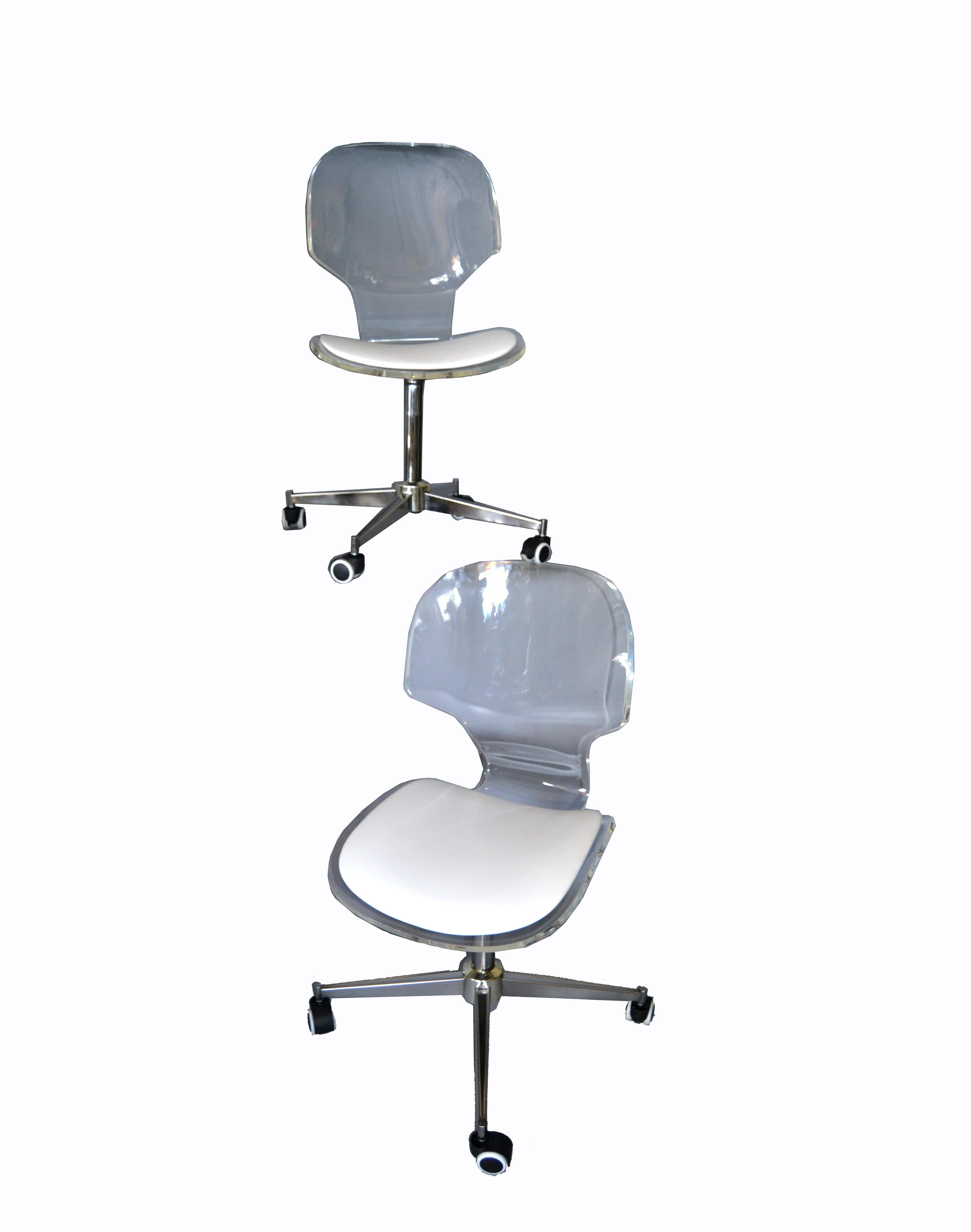 Mid-Century Modern classic pair of 1960s Lucite desk chairs with chrome swivel base on casters.
The chairs are very comfortable and perfect for your desk or vanity.
Clear acrylic molded seat provides ergonomic style support. White vinyl chair pad