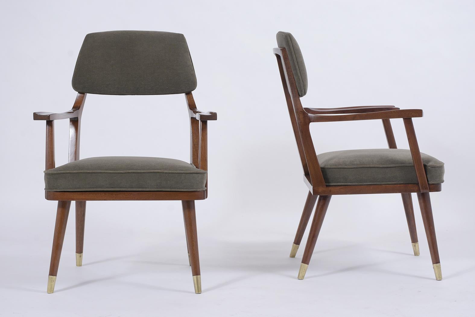 These beautiful Mid-Century Modern armchairs are expertly crafted out of walnut wood and are professionally restored. This set of side chairs features a sleek design frame newly stained in a dark walnut color with a lacquer finish and has