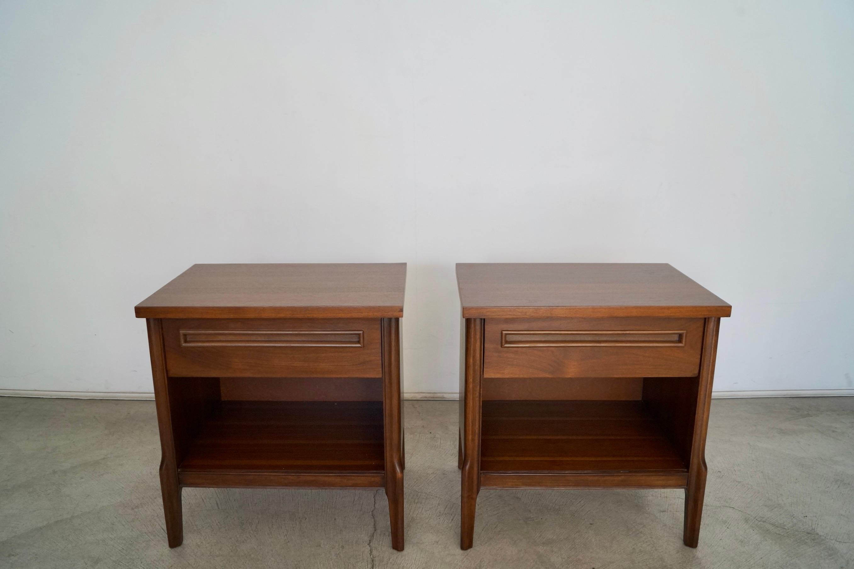 Vintage 1960s Mid-Century Modern pair of night stands for sale. Made of walnut, and have been professionally refinished. They're in excellent condition, and are really well made. They have a Classic and clean design with a recessed handle in the