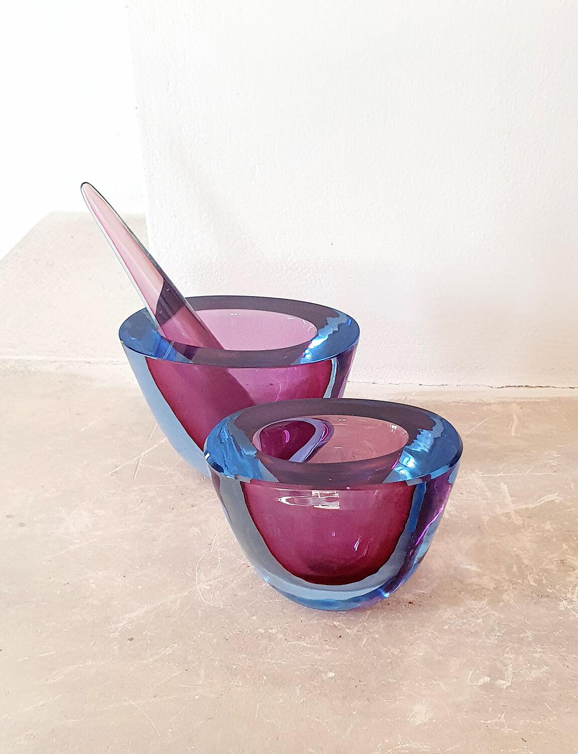 An extraordinarily rare and beautiful find. This pair of glass bowls (or mortars) are hand-blown 1960s Murano glass by Flavio Poli with a deep inner pink core and pale blue surround. They have their original pestle still intact and make for