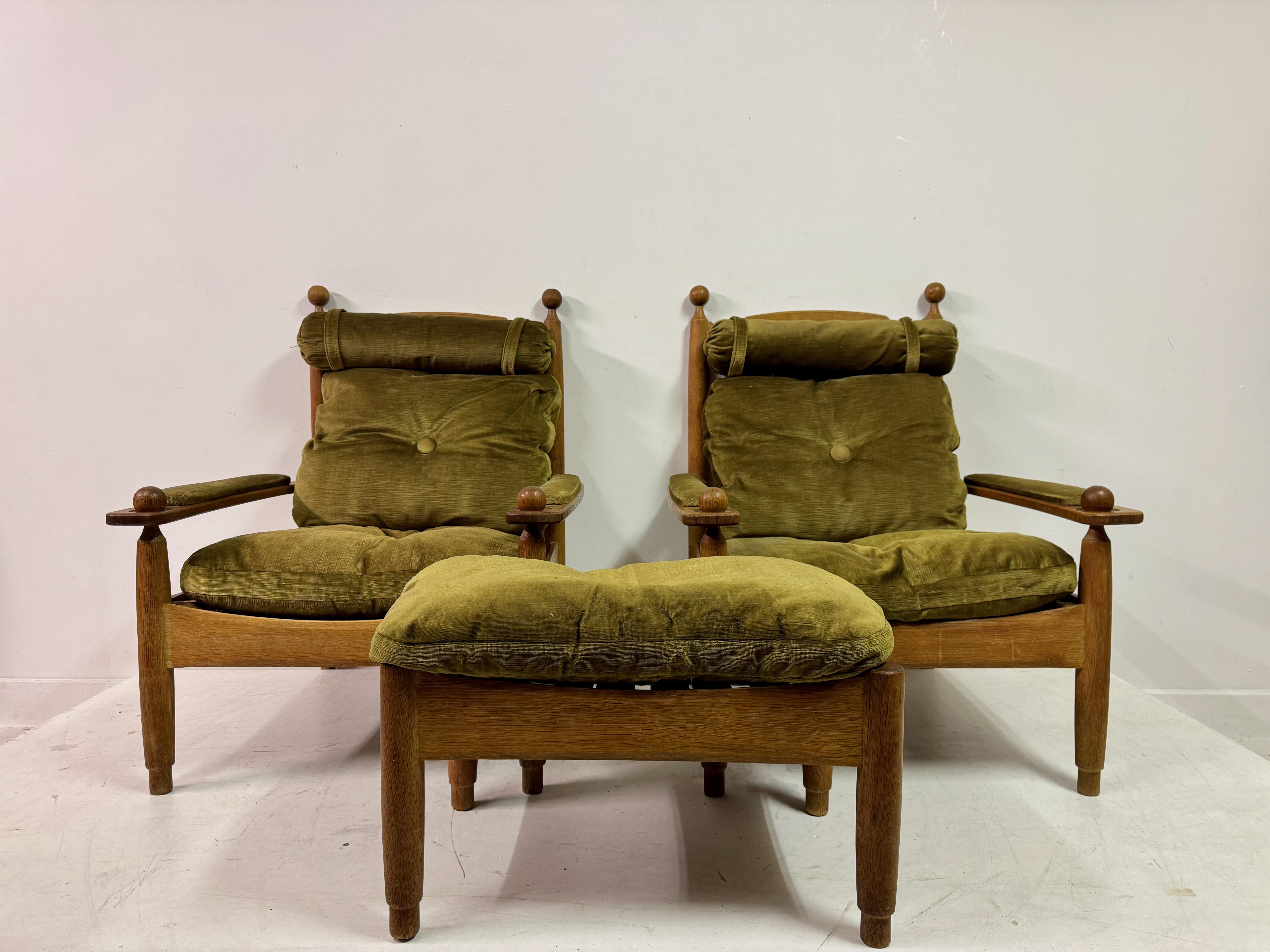 Pair of oak armchairs with matching stool

1960s Netherlands

This striking set of mid-century Dutch furniture includes a pair of oak armchairs accompanied by a matching stool. The chairs feature a sturdy oak frame with clean, angular lines softened