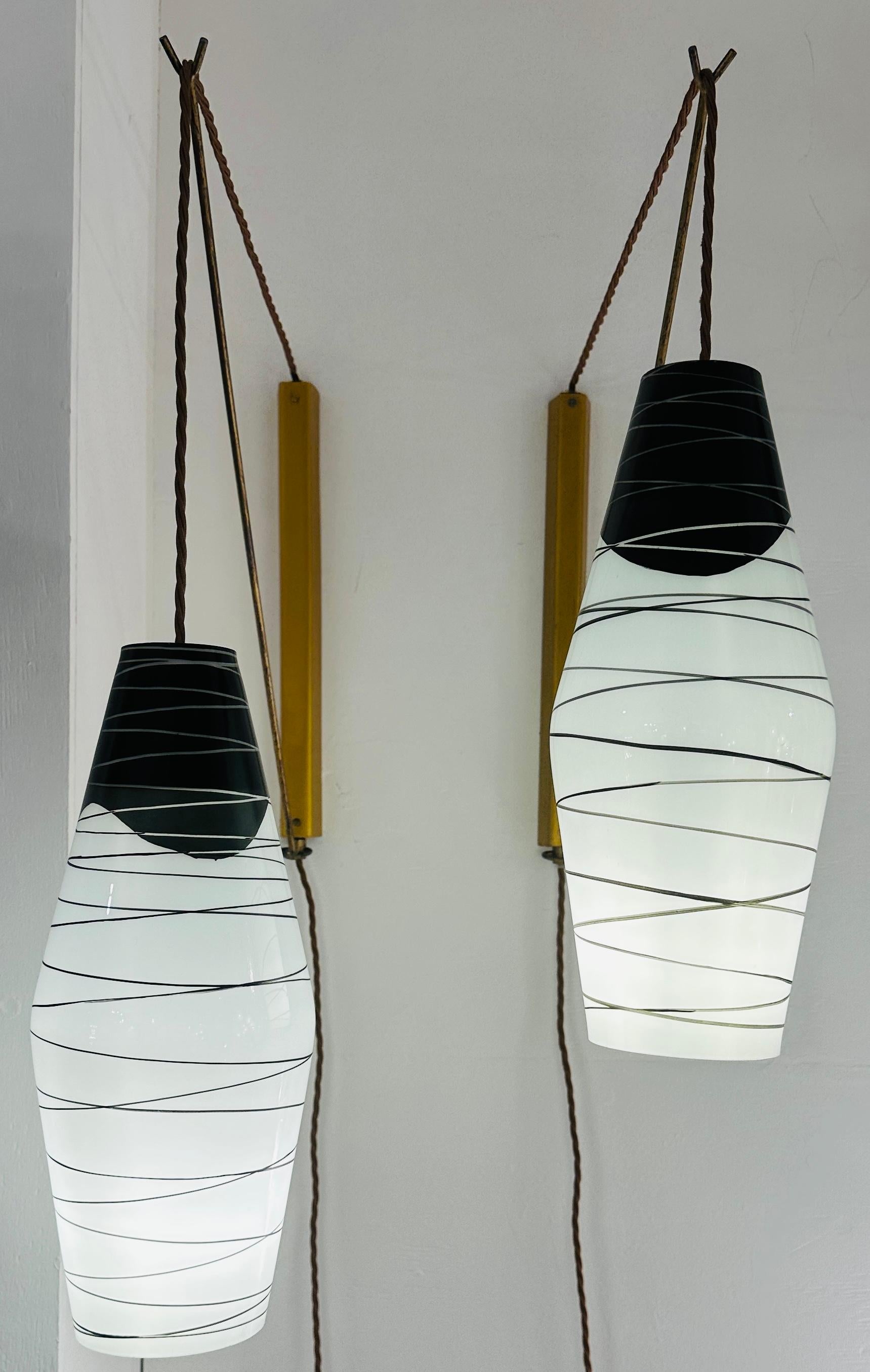 Pair of 1960s Czech wall hanging suspended swivel and height adjustable wall lights. The thick opaline glass shades are hand-painted in a matching geometric design and designed by Antonín Junek and manufactured by Zukov, Valašské Meziříčí in