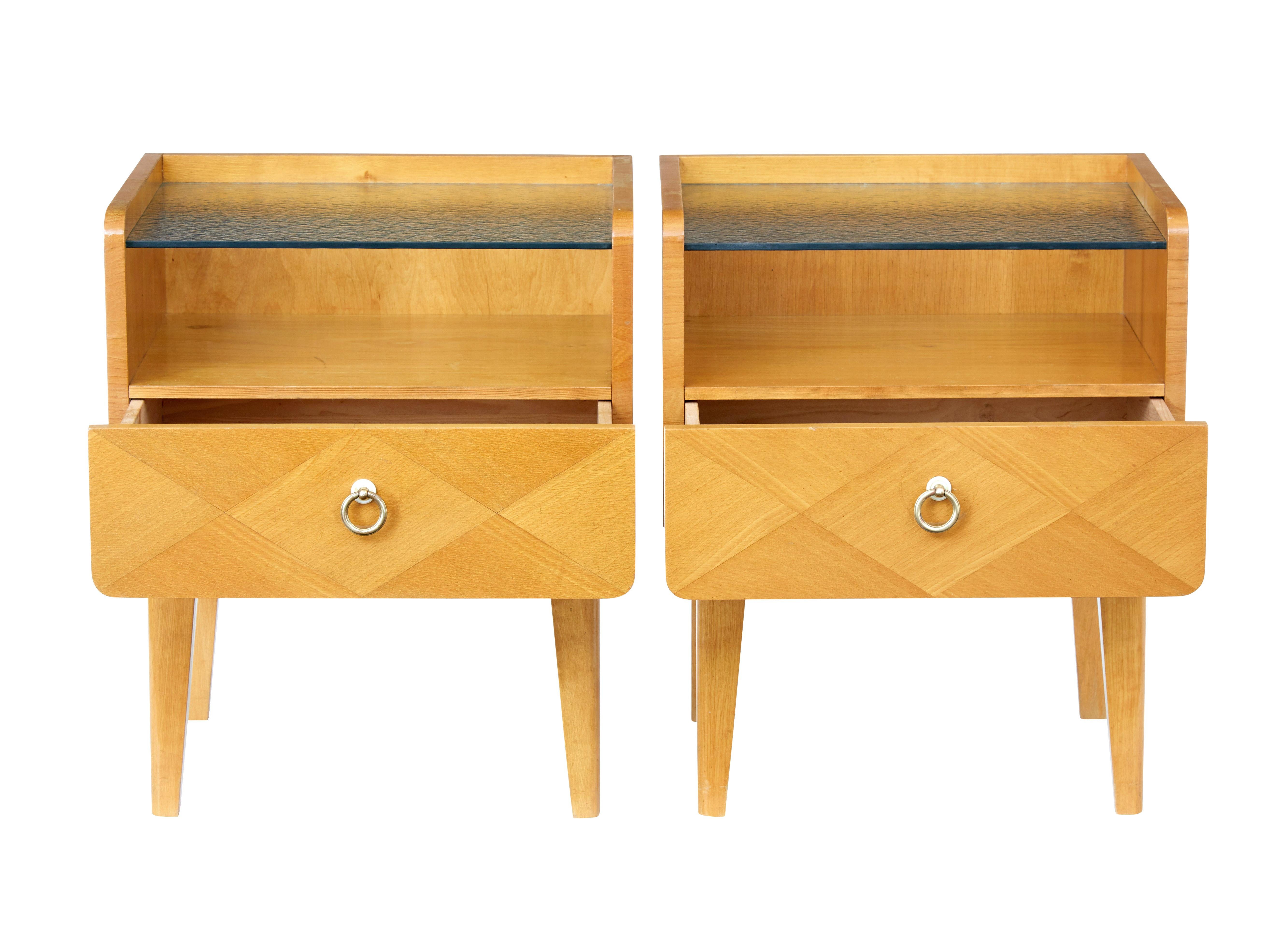 Good quality pair of Swedish elm bedside tables, circa 1960.

We have a pair of the same design in birch as these pair of tables. Frosted glass top surface with single drawer to the front.

Some marking and wear to wood work, ideally needing a