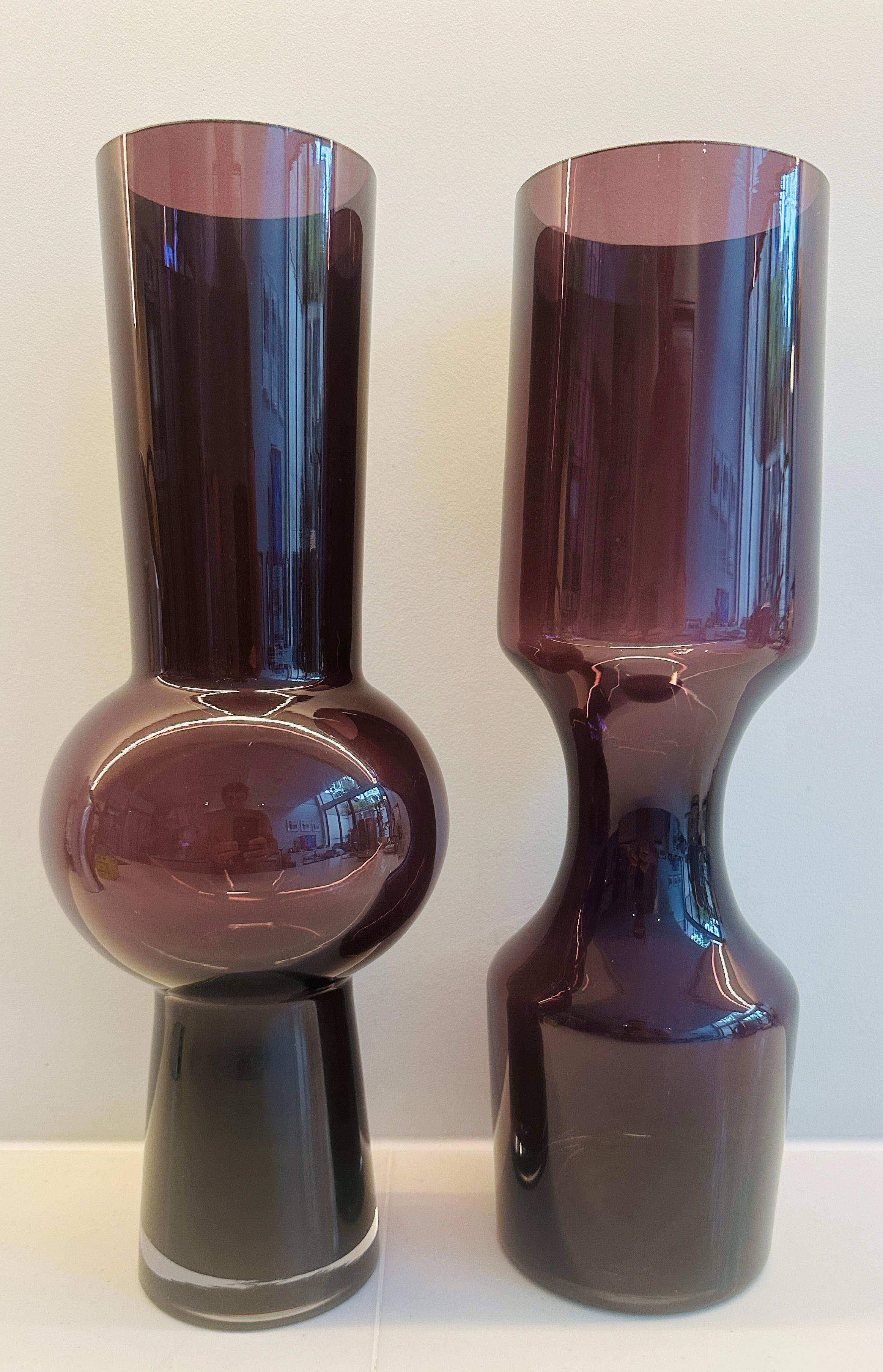 Coppia di vasi vintage in vetro viola scandinavo degli anni '60 che vendo insieme a causa del loro design a incastro.  Il vaso con la parte centrale a bulbo presenta una piccola scheggiatura sul bordo interno, illustrata nelle immagini.  Le basi di
