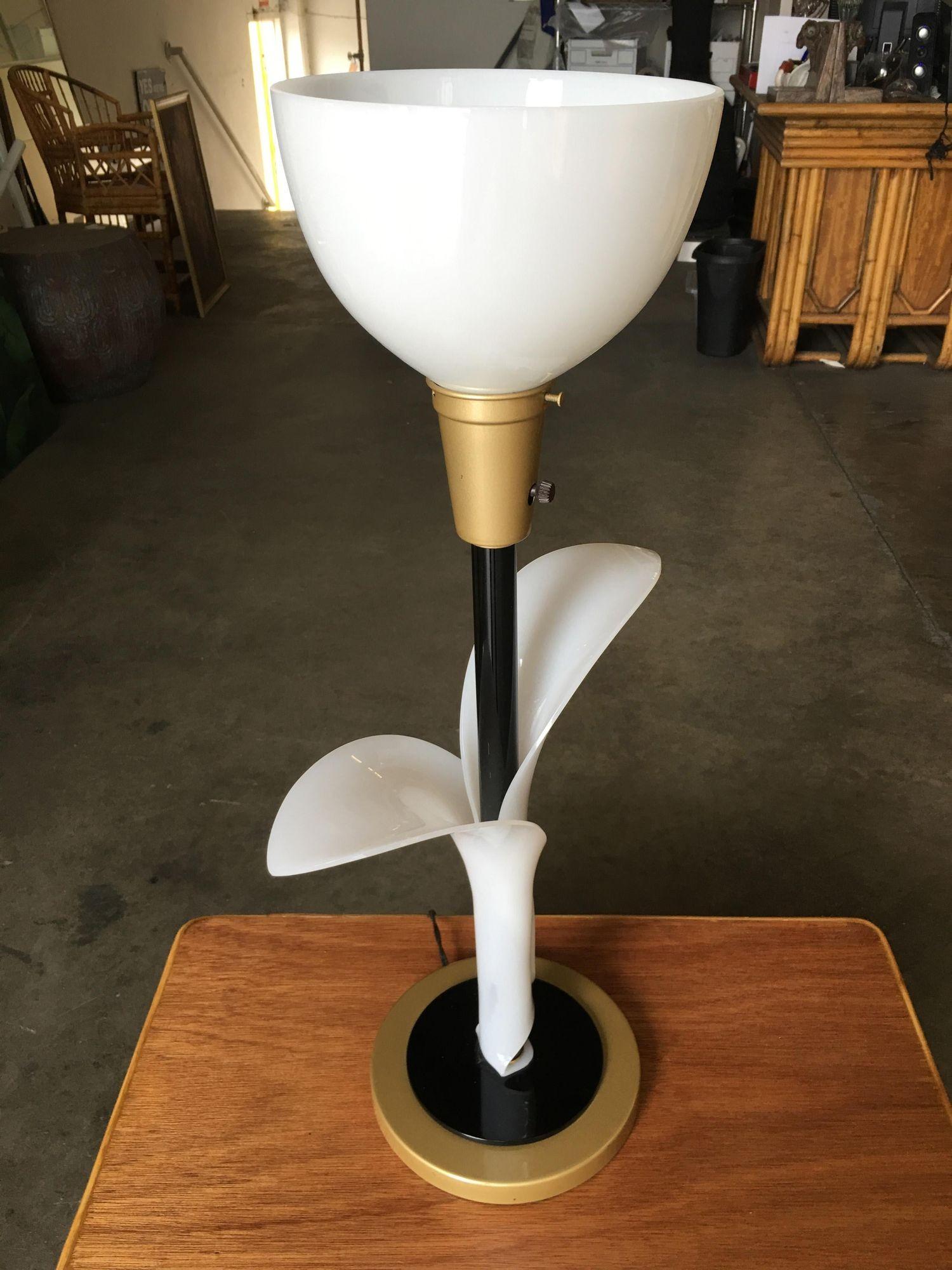 These exceptional pair of 1960s tulip table lamps crafted by Rembrandt Lamp boast leaf-shaped shafts delicately fashioned from ivory-toned acrylic. The acrylic gracefully encases the brass base and a sleek black-painted spine. 

Completing the lamps