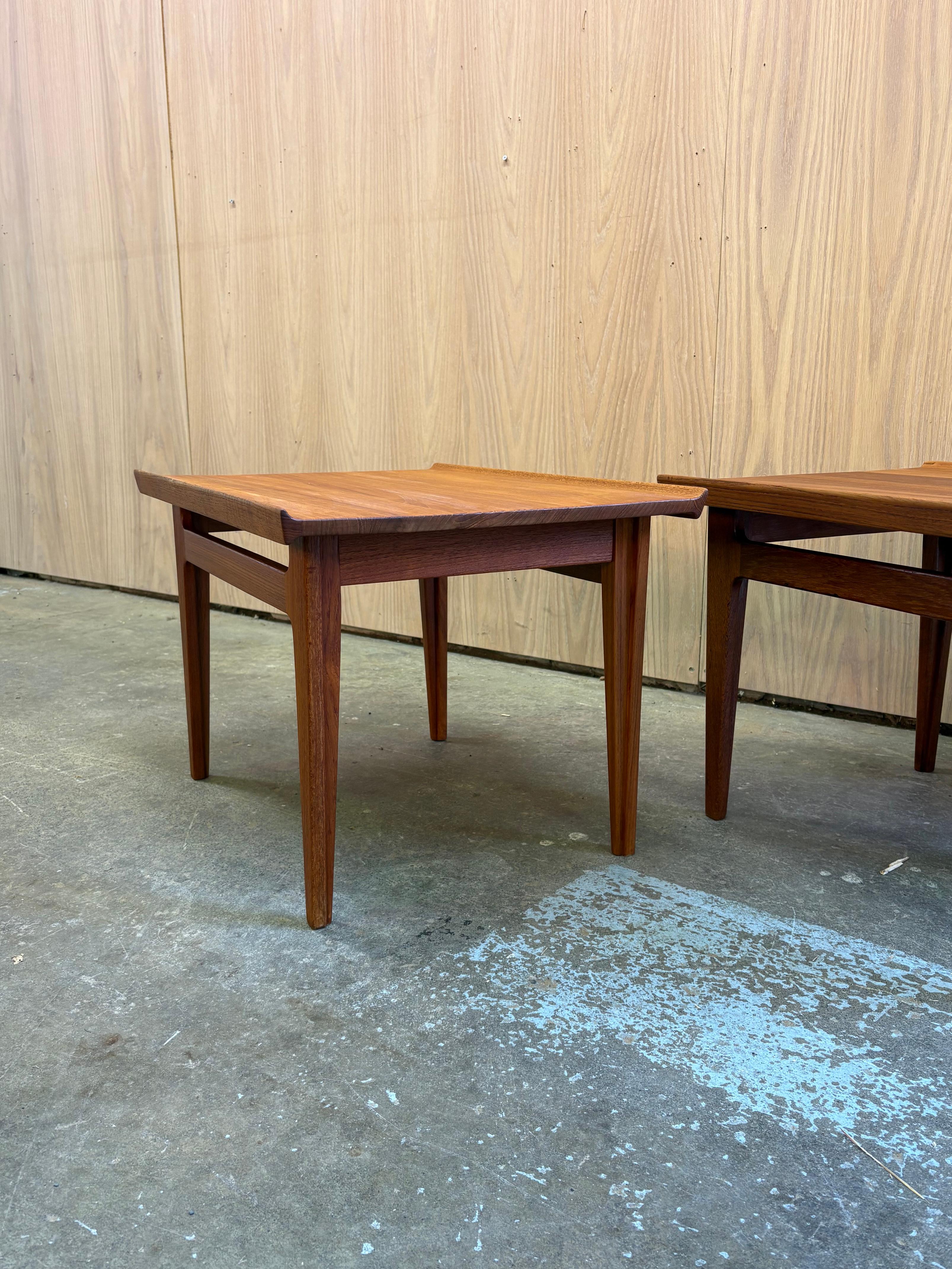 A beautifully matched pair of 1960s teak end tables designed by Finn Juhl for France & Son. These tables showcase Juhl’s signature lightness and sculptural clarity, with softly beveled tops, elegant tapered legs, and a refined floating-apron