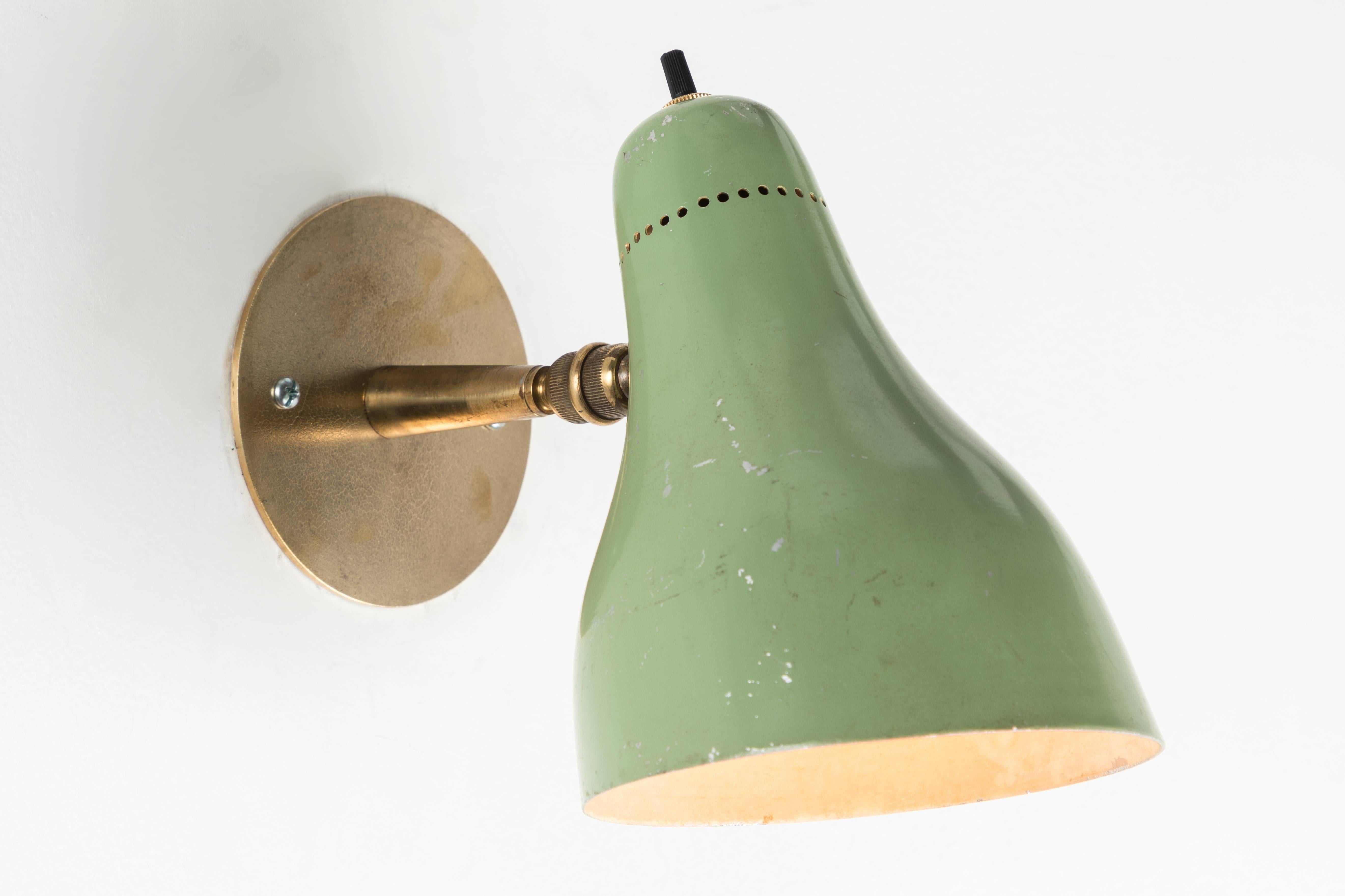 Pair of 1960s Stilux articulating sconces in the manner of Gino Sarfatti. Executed in brass and green painted aluminum. Sconces pivot up/down and left/right on a ball joint. Wired for US electrical . Custom patinated brass backplates. Accommodates a