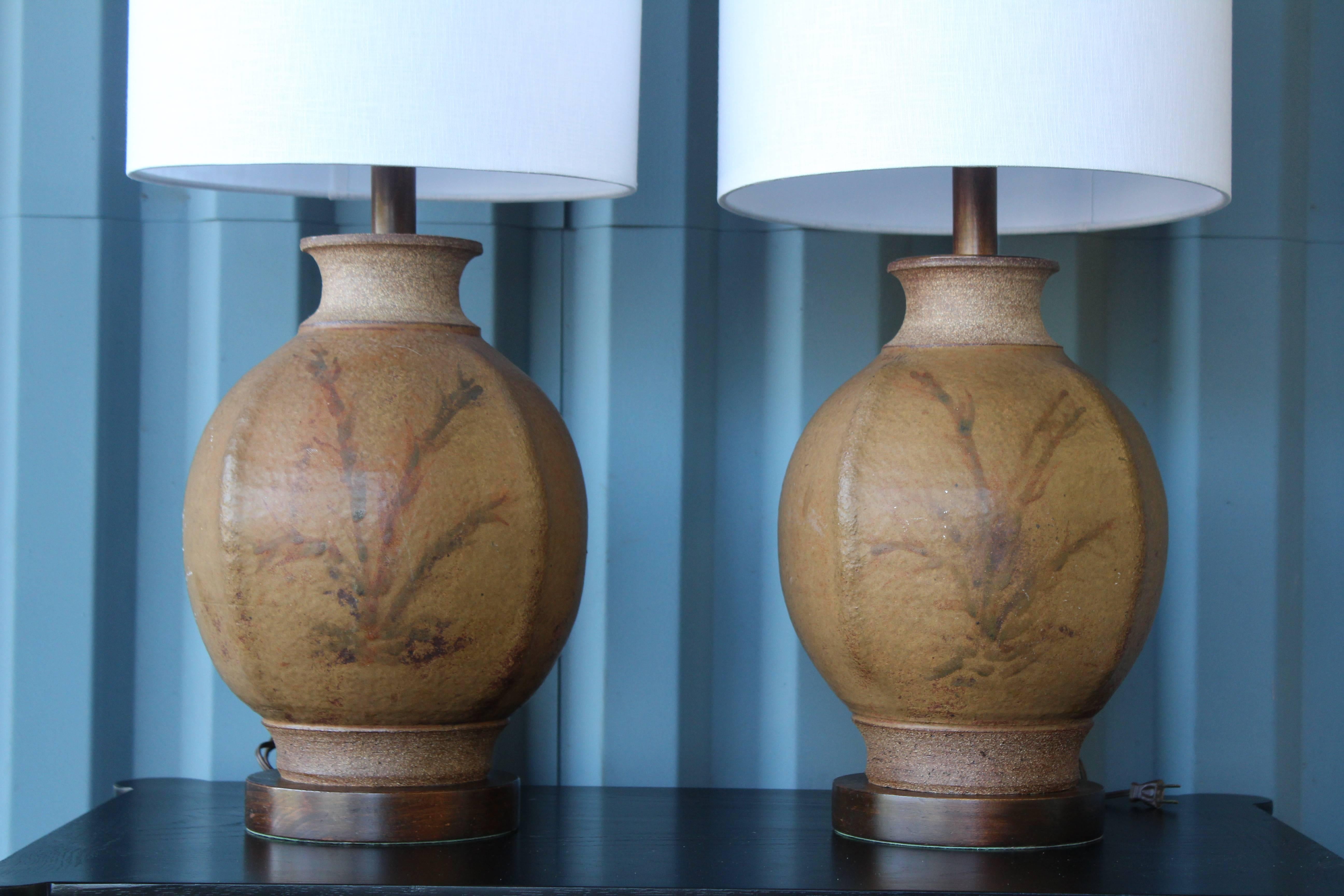 Pair of 1960s hand thrown stoneware lamps by Brent Bennett. Signed near the bottom of each lamp. Includes white linen shade.