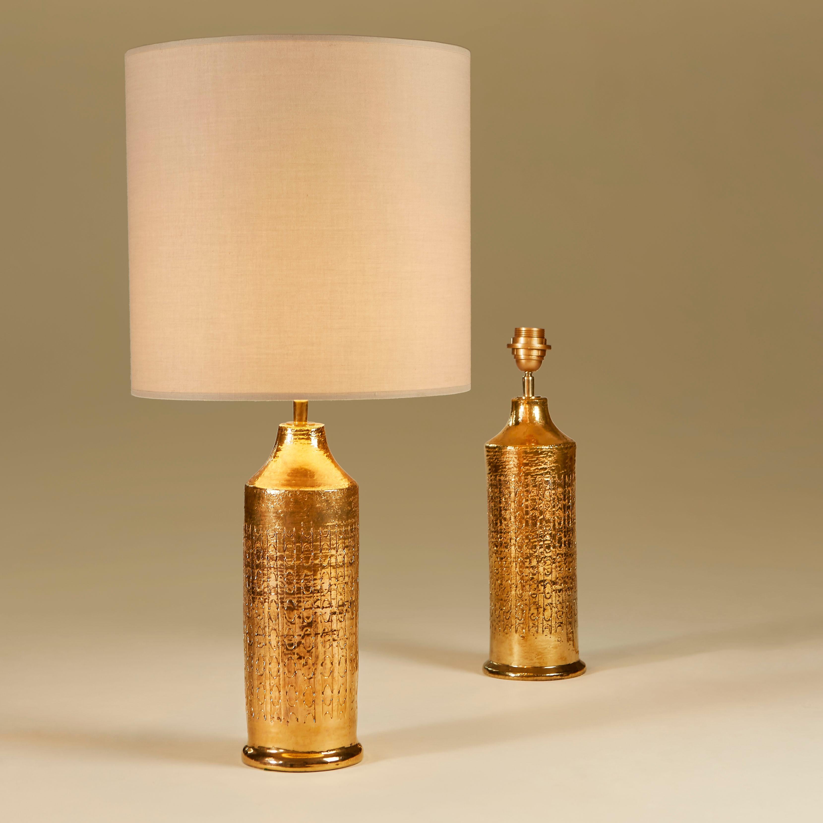 Wunderschönes Paar großer Keramiklampen von Bitossi mit handgeschnittenem dekorativem Muster in reicher Goldglasur.

Die Größe einschließlich des Schirms beträgt 73,5 cm Höhe und 35 cm Durchmesser.