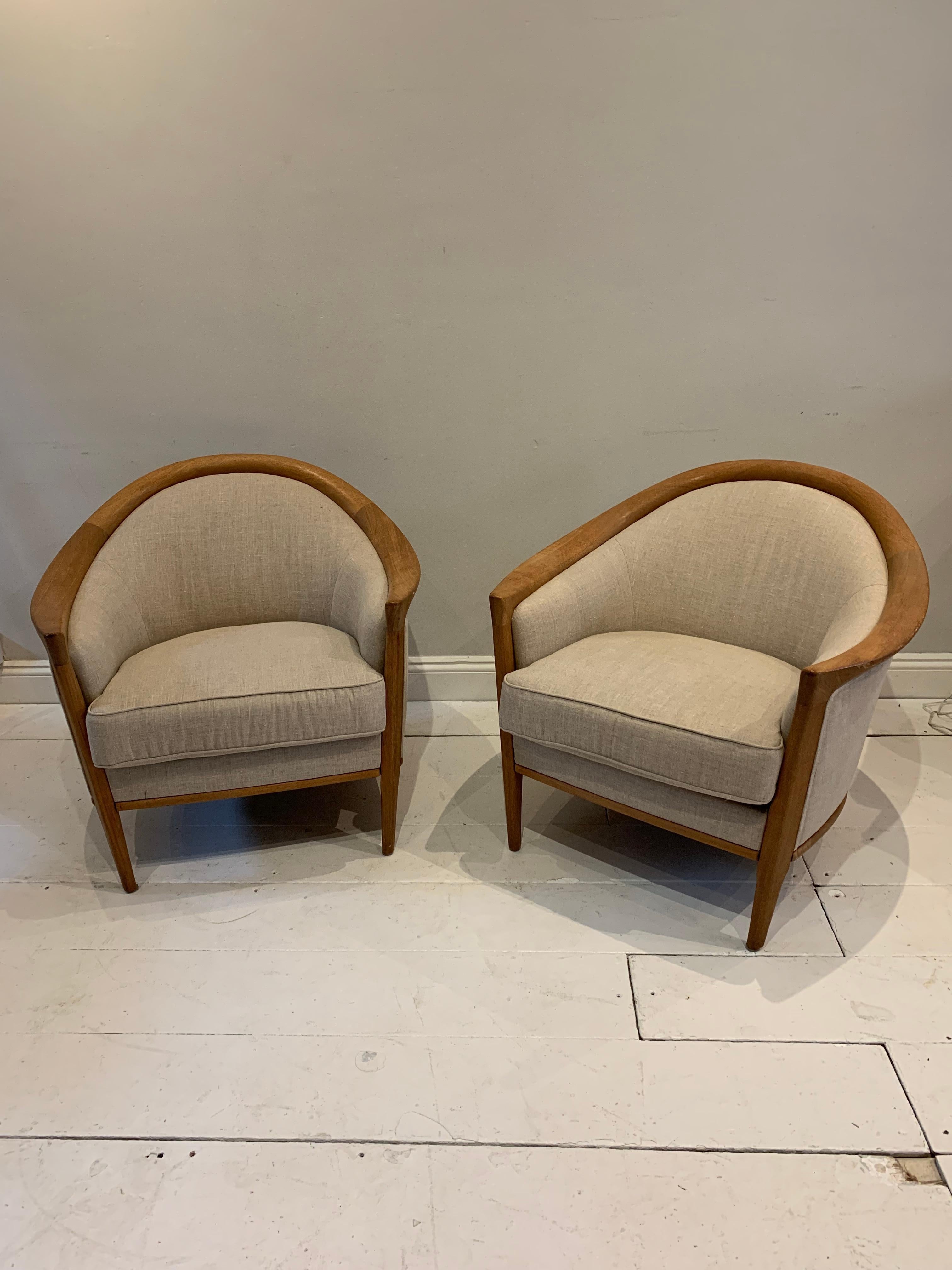 A stylish pair of very comfortable Swedish oak armchairs. There is a very small difference in their size which is barely noticeable .
The backs are deep and curved with thick cushions. The wood is a dark honey colour. The armchairs have recently