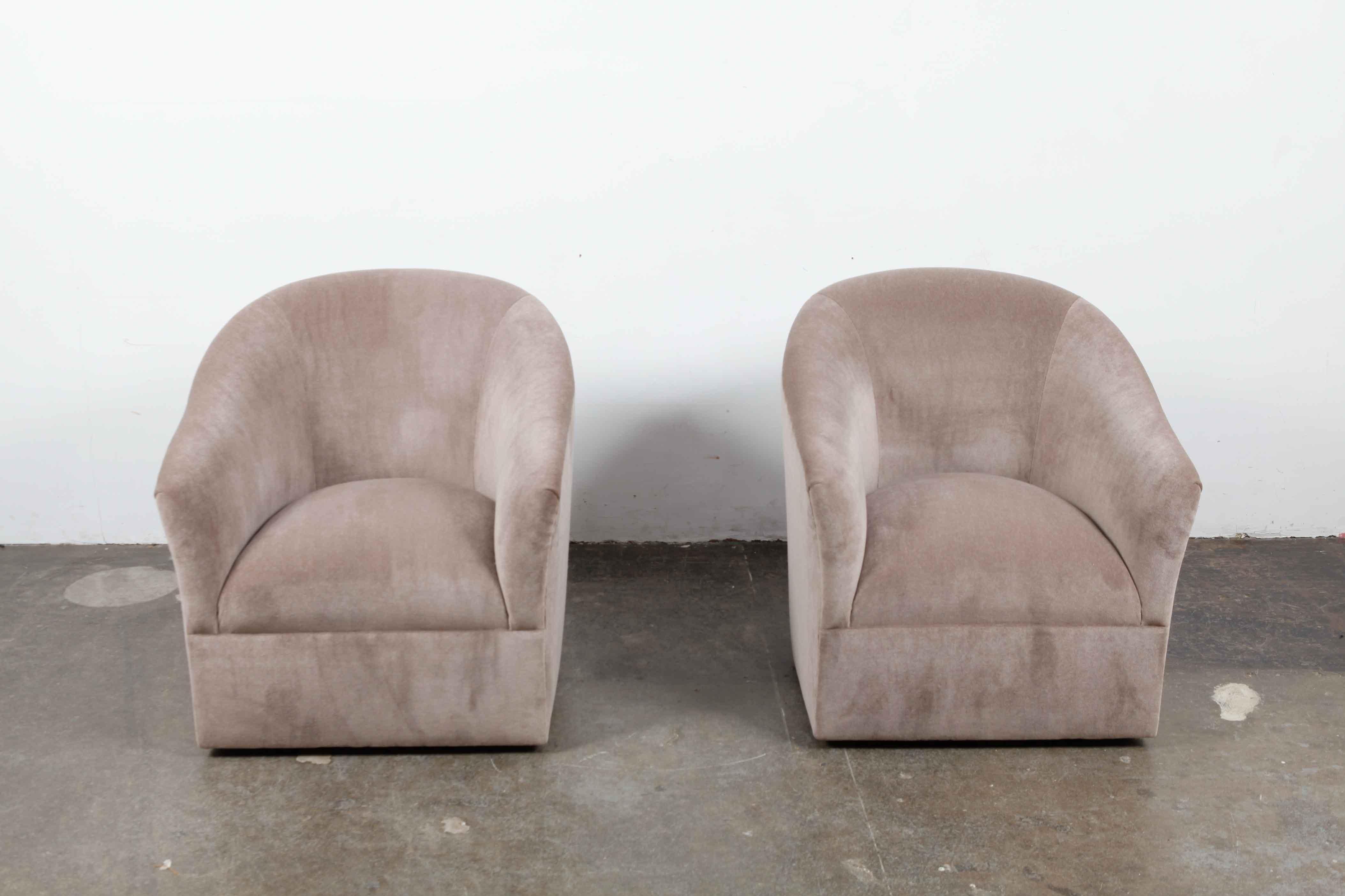 Pair of 1960s American swivel chairs newly upholstered in a grey or brown mohair with a tight back or tight seat upholstery style. Taller, curved back with sloping arms make these an elegant and clean chair that are also quite comfortable.
