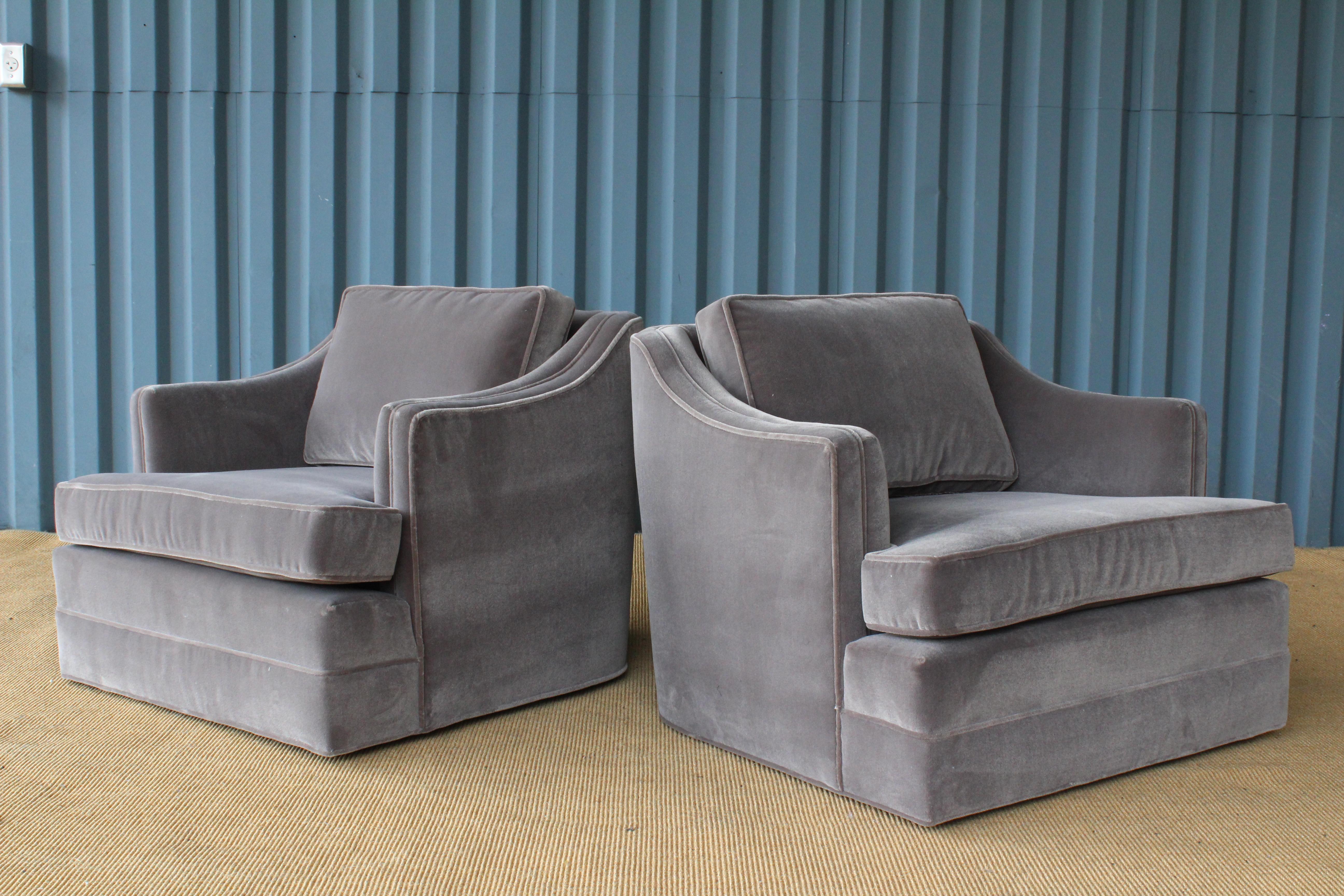 Pair of 1960s club chairs on swivelling bases. New grey mohair upholstery.