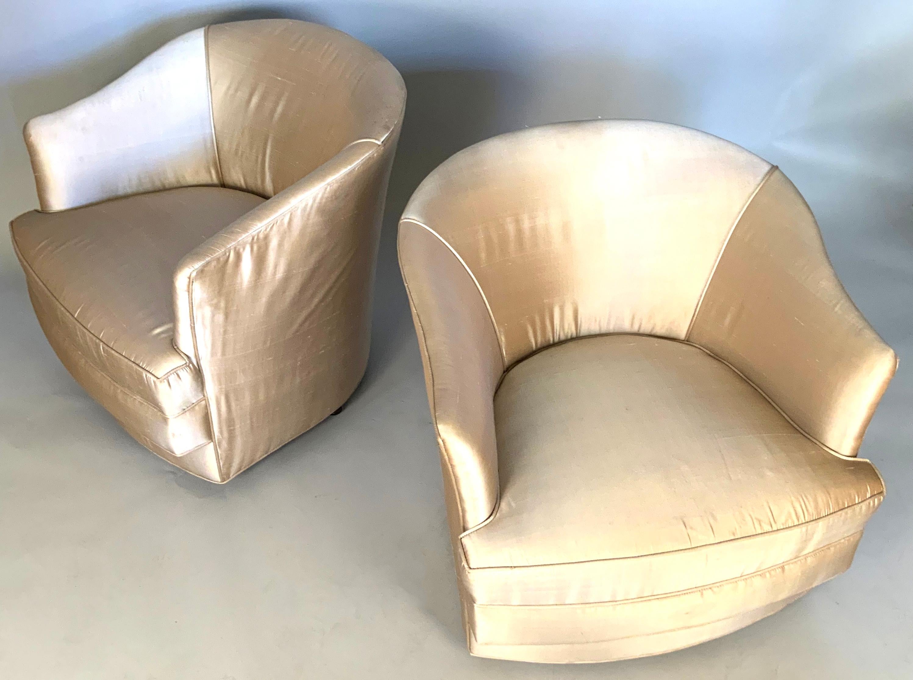A very nice pair of vintage 1960s swivel tub shaped lounge chairs by John Stuart. Nice scale and proportion, mounted on swivel bases with casters, in their original champagne color silk, which shows average wear for the age, with frayed edges at the