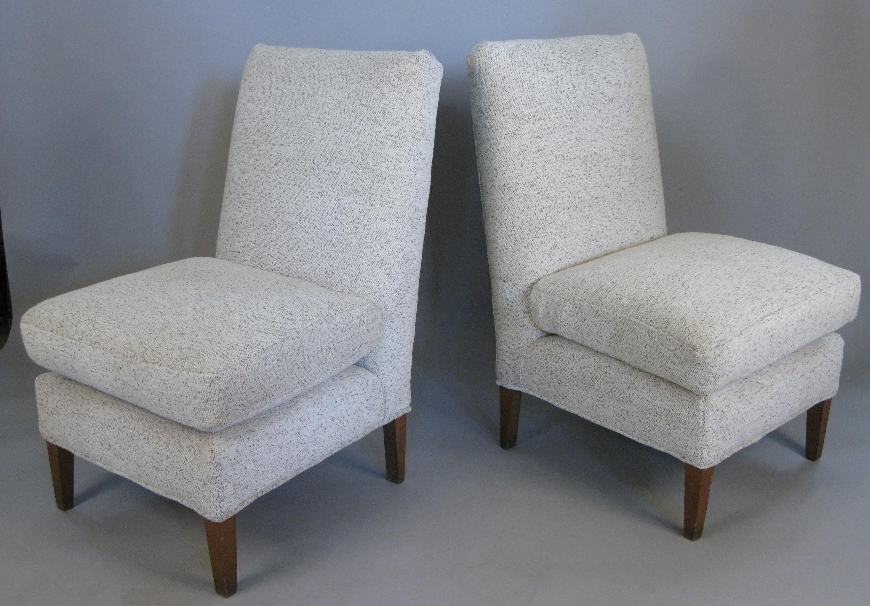 A charming pair of vintage 1960s armless slipper lounge chairs, with high backs and down-wrapped foam seat cushions. These have been reupholstered with a light oatmeal colored thick pile soft upholstery fabric.