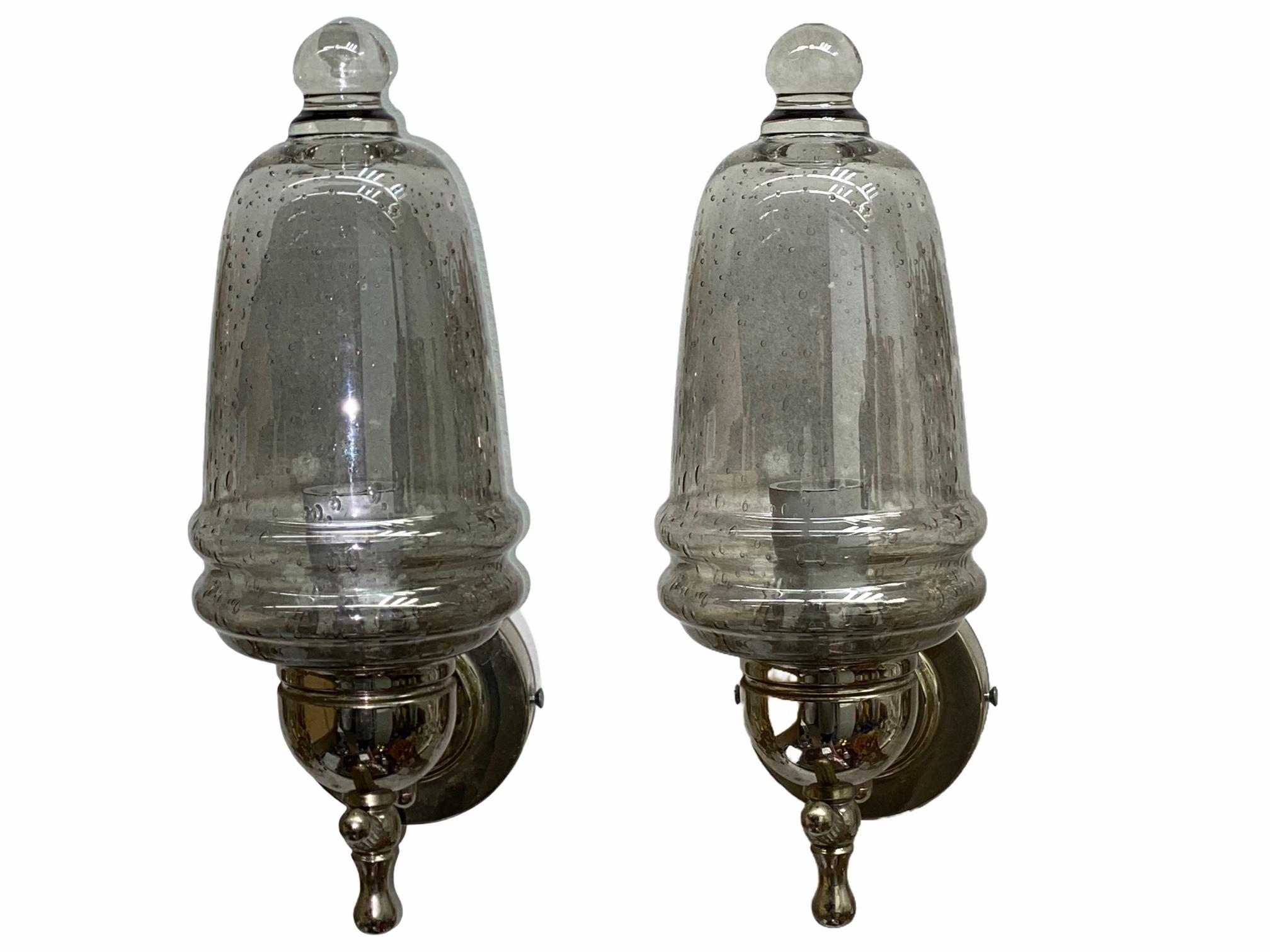 A stunning pair of brass and small air bubble smoked grey glass wall sconces. Each consisting of a stylish Mid-Century Modern style design. Each fixture requires a European E14 / 110 Volt candelabra bulb, up to 40 watts. Found at a estate sale in