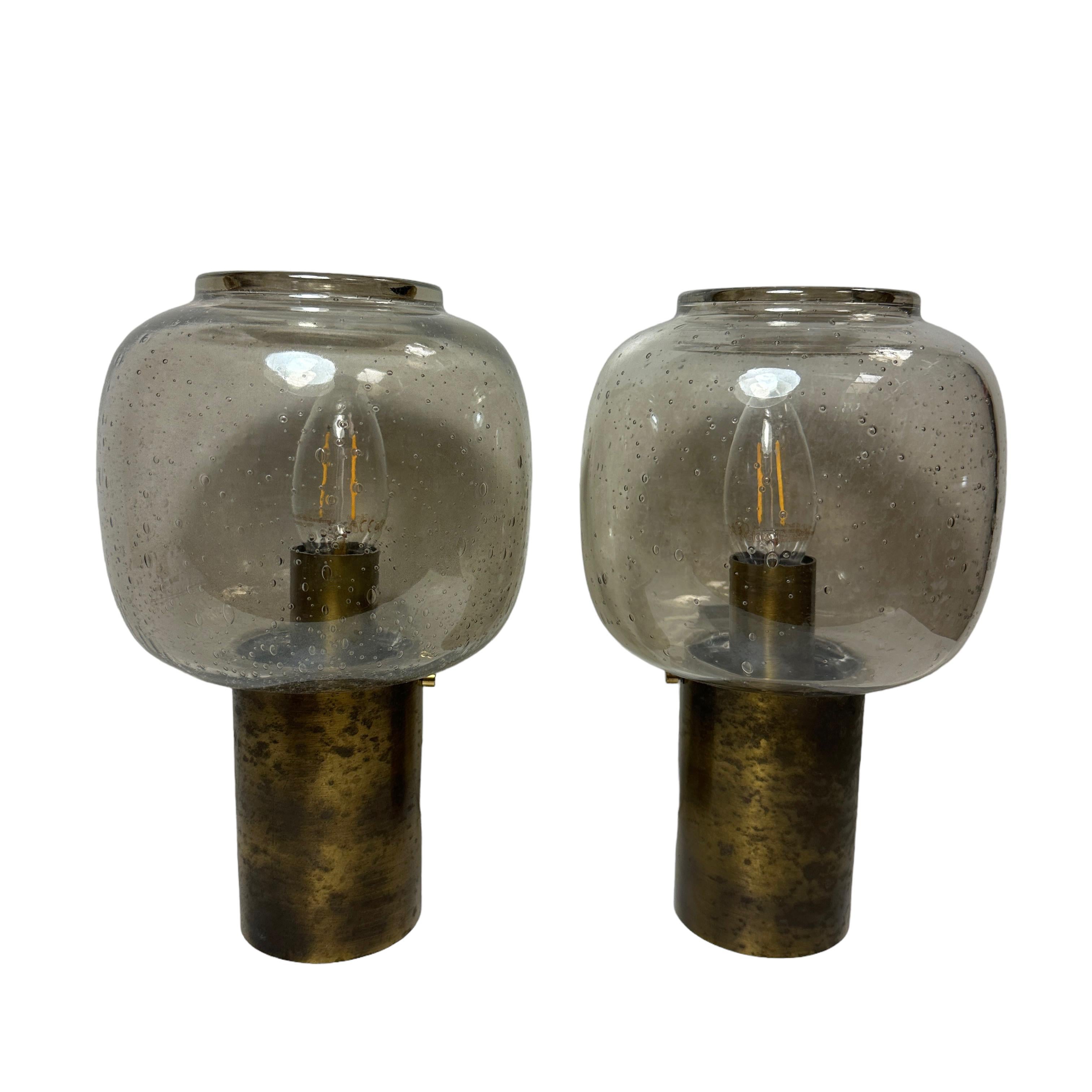 A stunning pair of tarnished brass and small air bubble smoked grey glass wall sconces. Each consisting of a stylish Mid-Century Modern style design. Each fixture requires an European E14 / 110 Volt candelabra bulb, up to 40 watts. Found at an