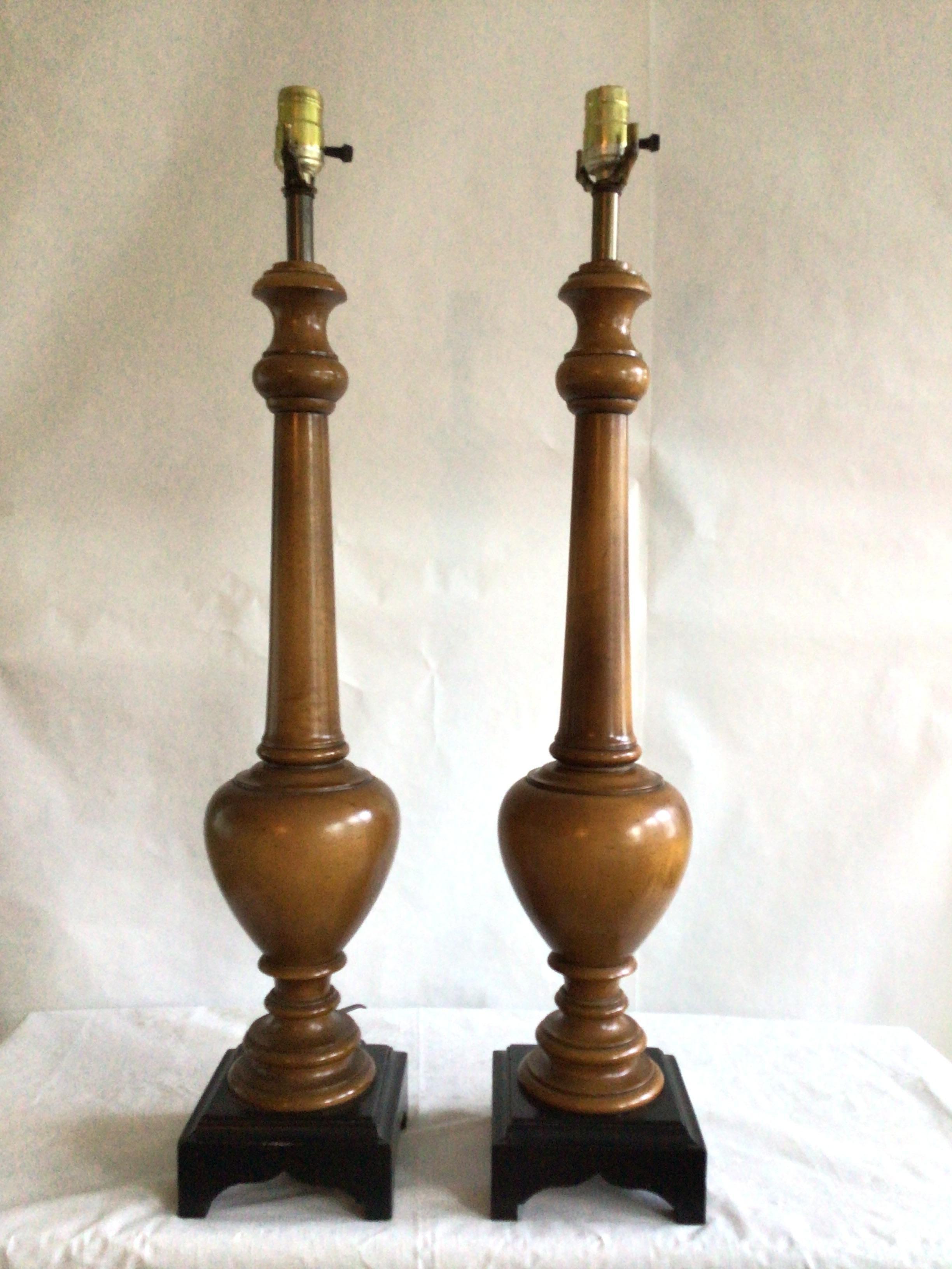 Pair of 1960s Wooden Lamps on Black Wood Base
Turned wood is accented by a black base for these pair of lamps 
A perfect choice where a pair of taller lamps and lighting is required
Needs Rewiring
Height to Top of Socket

