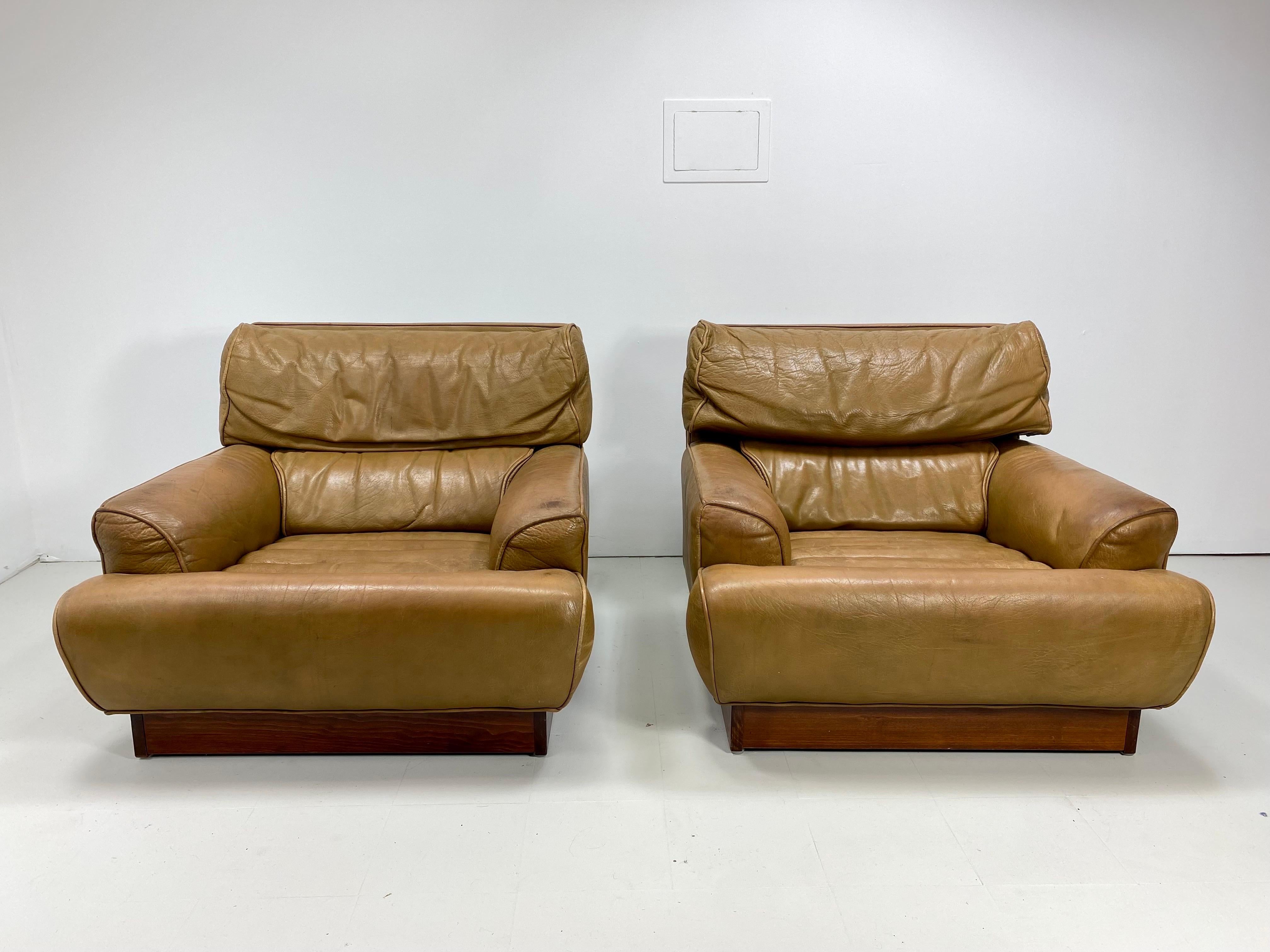 Pair of Arne Norell “Mexico” Lounge Chairs for Arne Norell Mobel AB. Sweden, 1970’s. Original high quality tan leather has a nice worn patina. Roll tufted seat. Wooden plinth base. 


