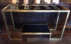 Coppia di consolle Art Deco in vetro nero e ottone degli anni '70