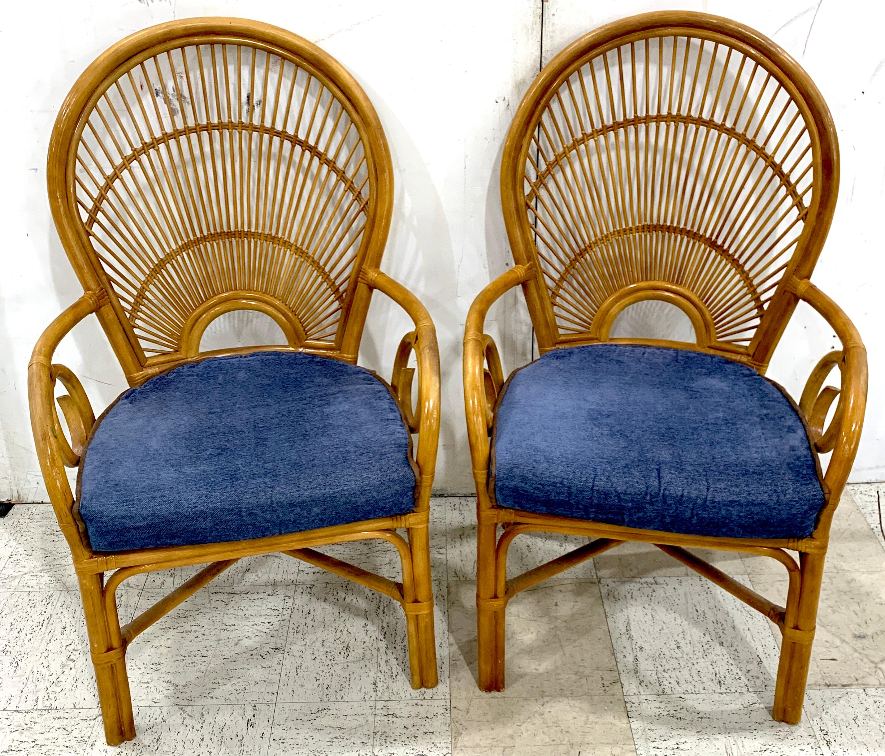 Pair of 1970s bamboo and rattan 'Sunrise' armchairs
Each one with finely woven reed and willow stylized back of three tier a 'Sunrise' (or Sunset)
With bamboo slat seats and vintage blue cushions
Measures: Each one is 43