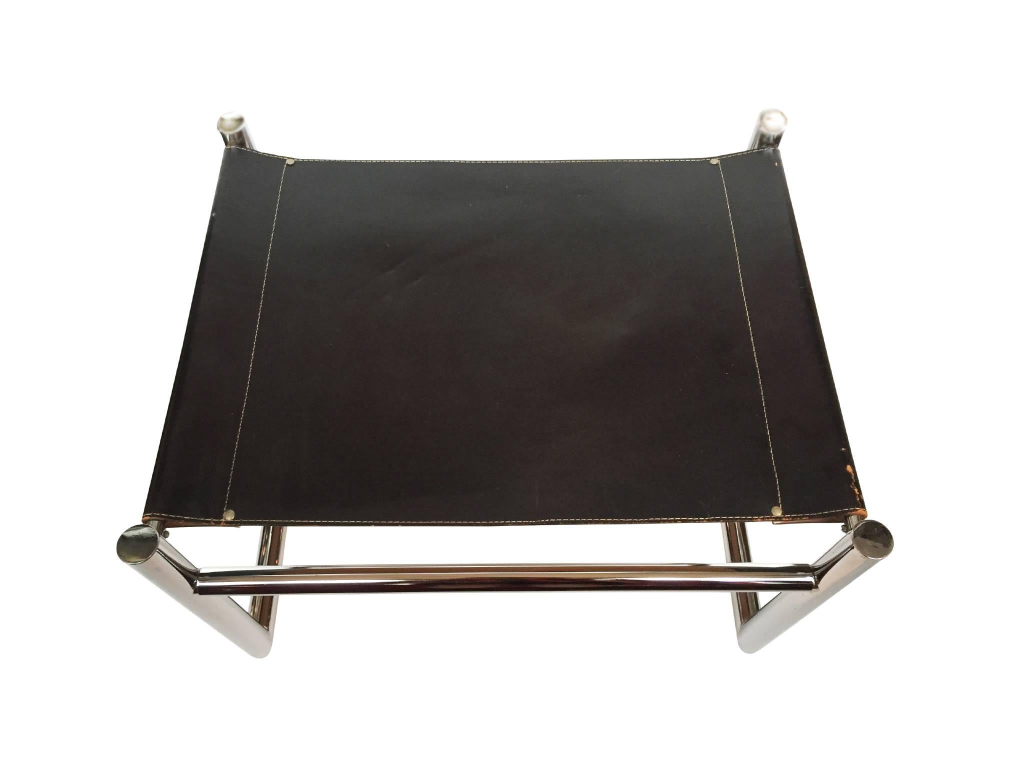 These classic ottomans or benches are comprised of sewn and stretched black leather upholstery and a chromed, tubular steel frame. They are in the minimalist tradition of Bauhaus design: clean lines and planes and austere use of materials. This