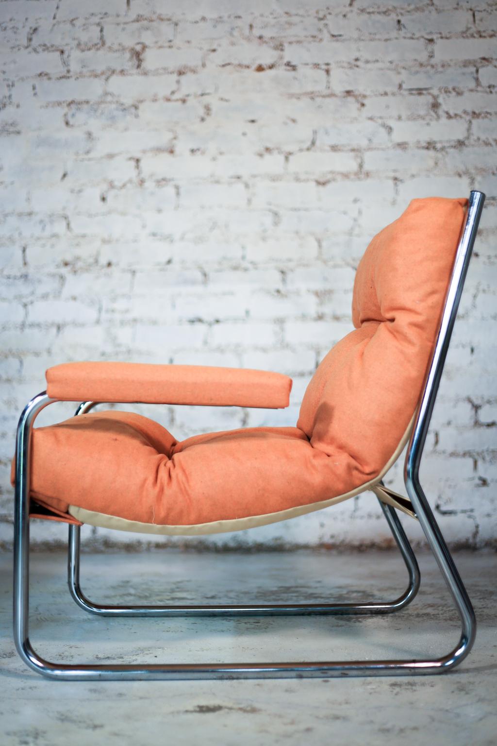 Two bent tubular steel and chrome-plated cantilever sling chairs that date from the 1970s, re-upholstered in marmalade orange upholstery felt.

 