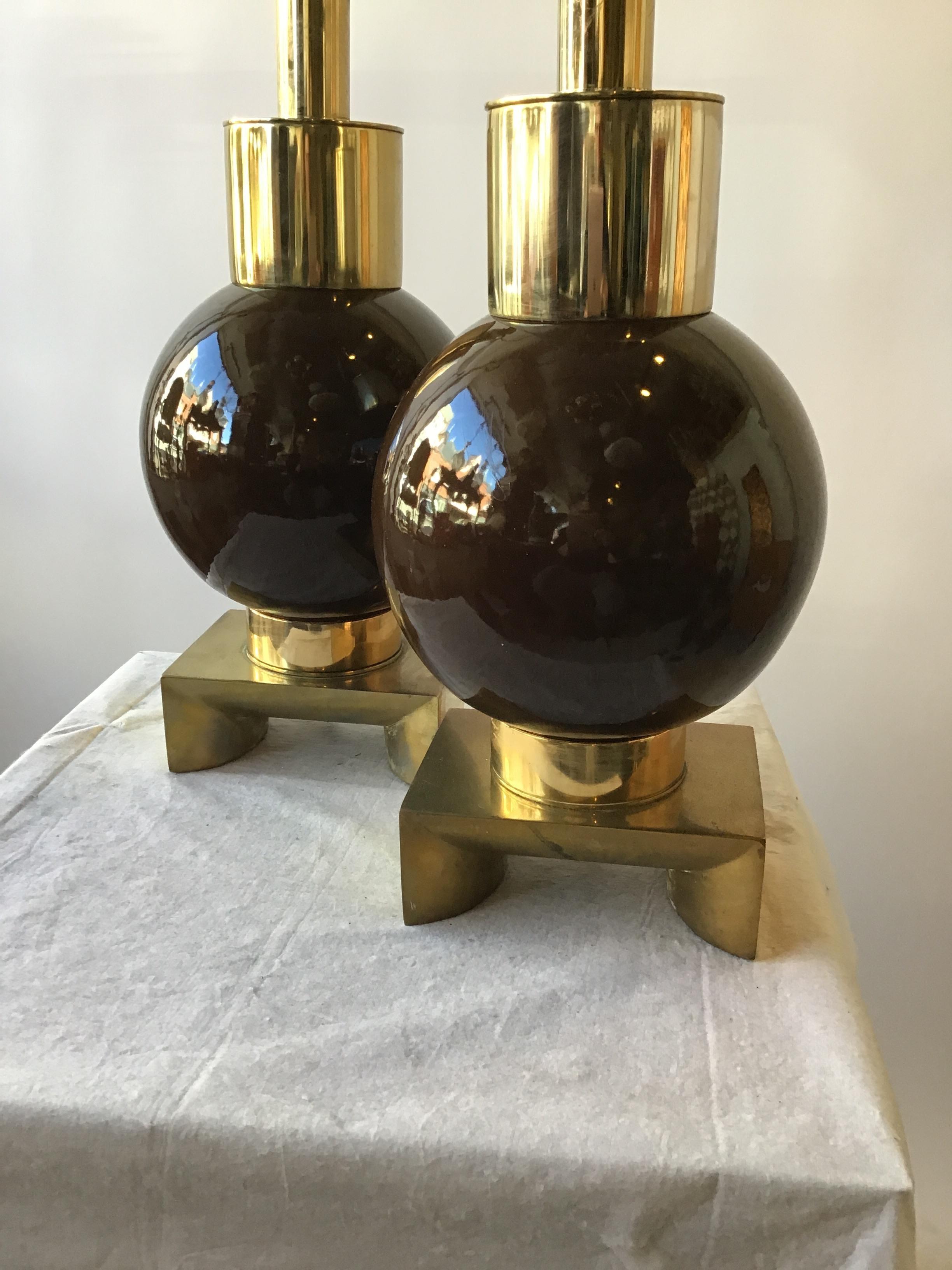 Pair of 1970s ceramic ball shaped lamps on brass bases. Made by Laurel. Super chic.