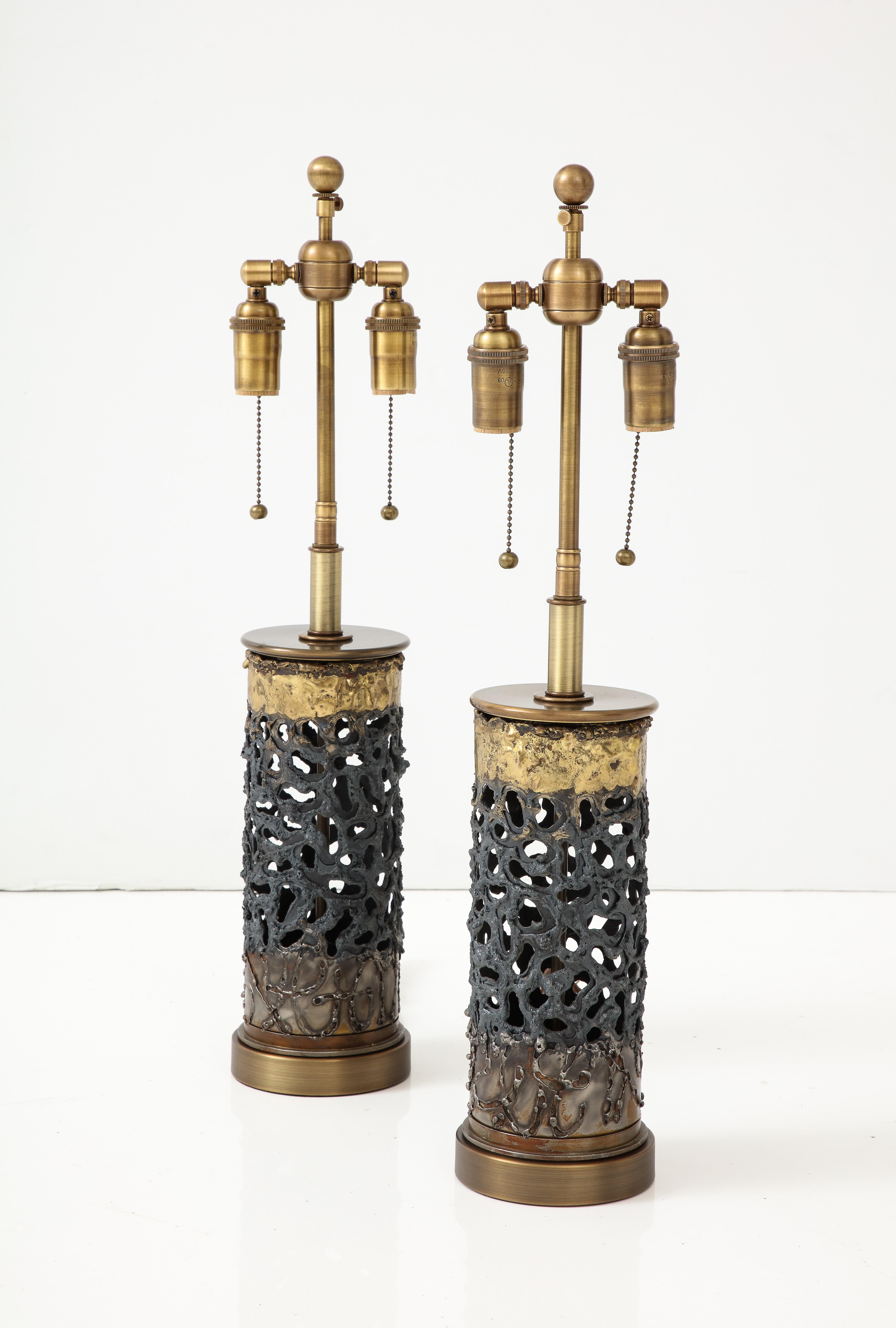 Pair of 1970's Brutalist Lamps.
The Brutalist column form lamp bodies have a n irregular pierced design,
and are finished in Bronze and Brass tones.
The lamps have been Newly rewired with adjustable Antique brass double clusters
that take standard