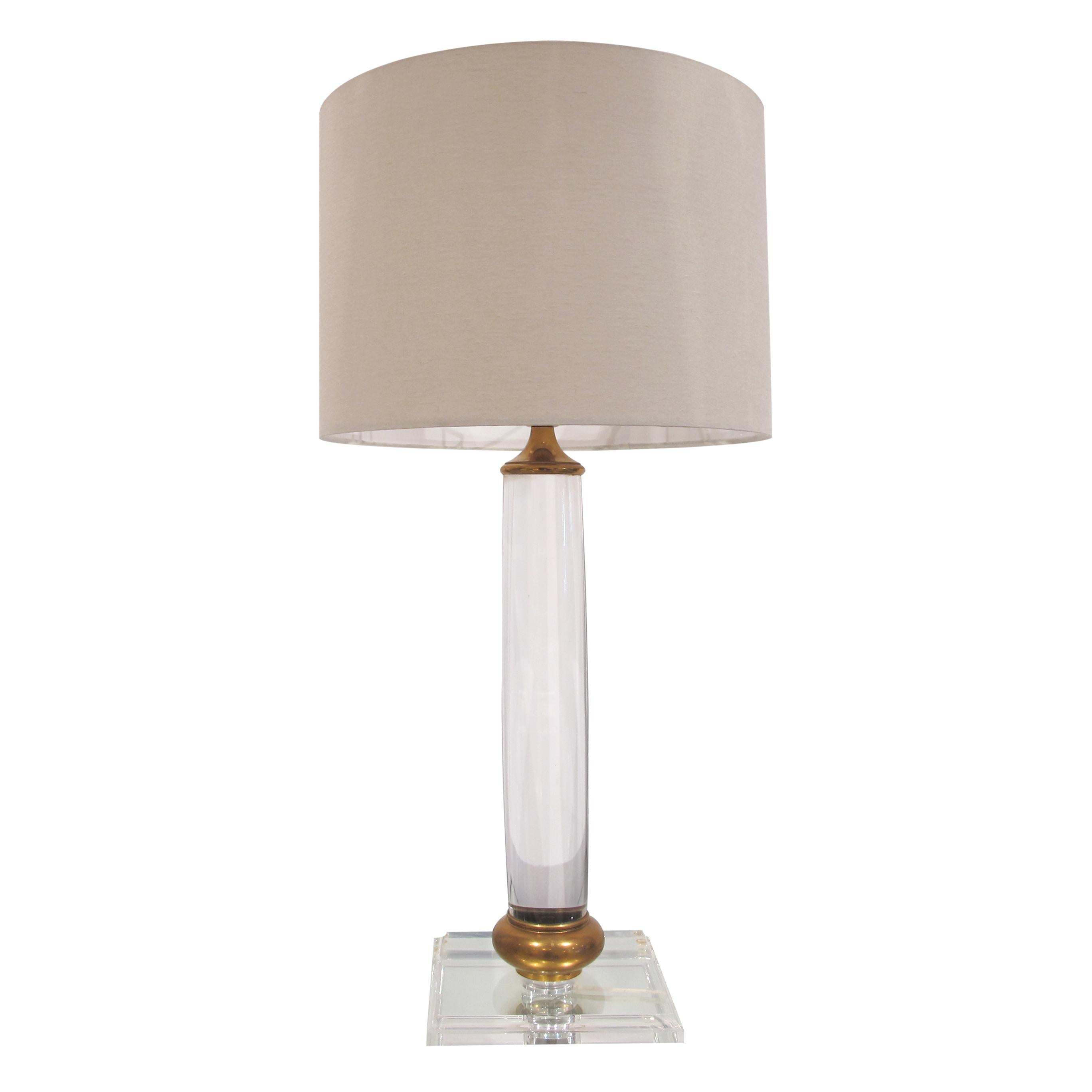 A stunning pair of tall Italian lucite/perspex table lamps mounted on a square base with a brass round trim at the base of the shaft. The lamps are of a simple elegant cylindrical design, the central brass stem is almost invisible due to the optical