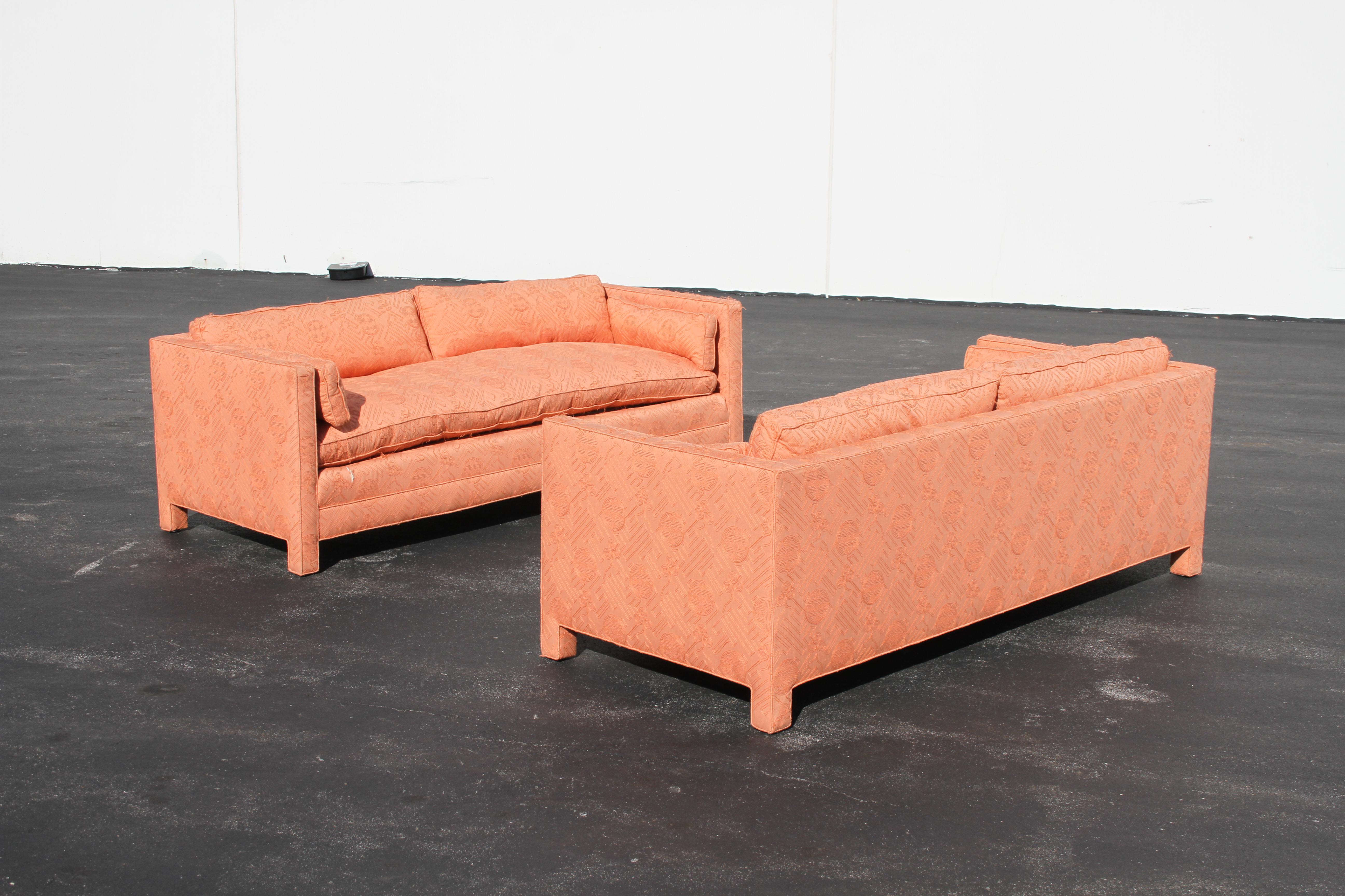 Pair of matching Hollywood Regency 1970s fully upholstered sofas with down seats, backs and arm cushions, designed by John Mascheroni for Swaim High point, North Carolina. Shown in original, Asian stitched pattern over silk. They must be