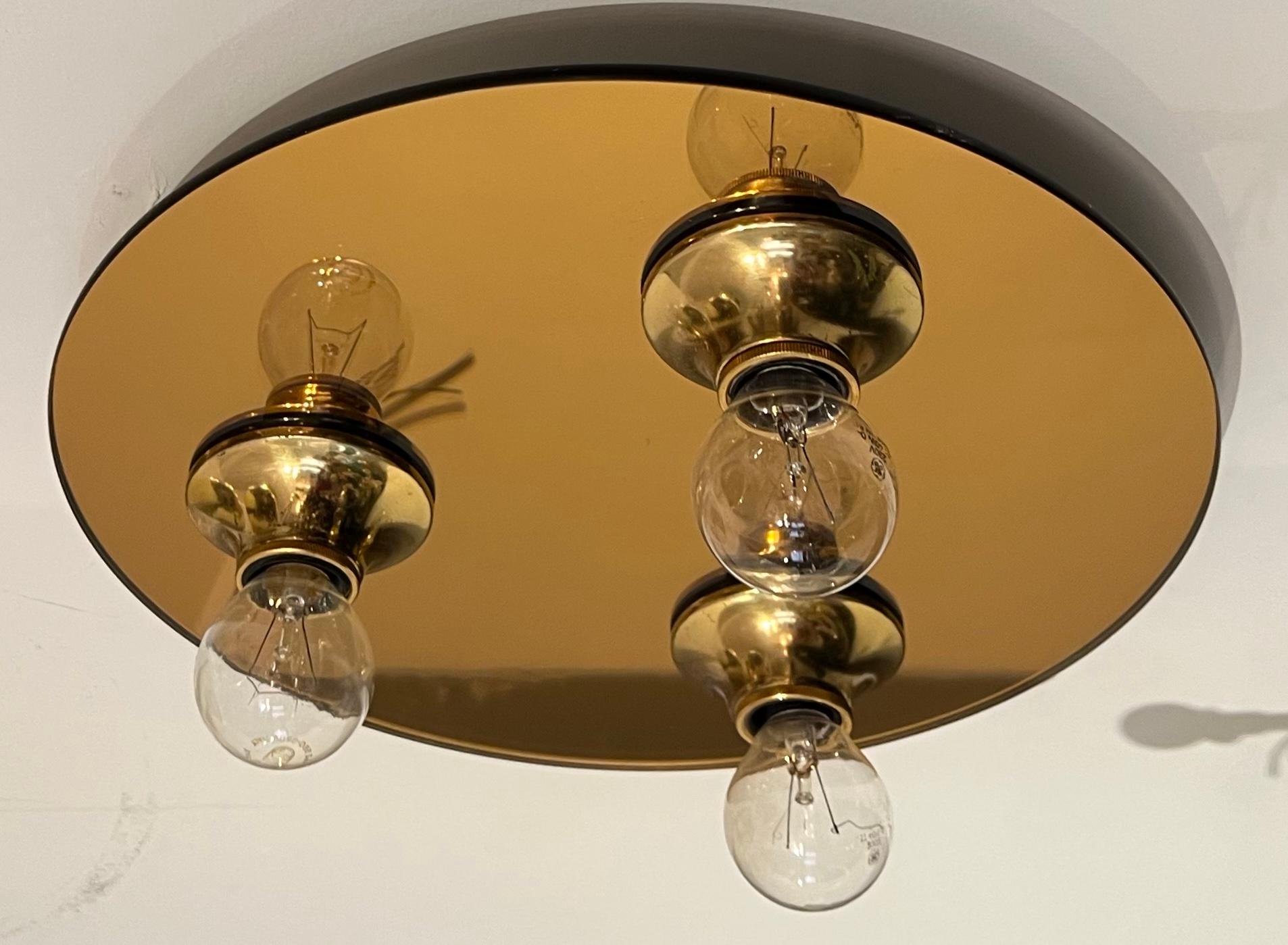 A spectacular pair of high style 1970s copper/bronze mirrored round flush lights with gold space age sockets. Rewired.