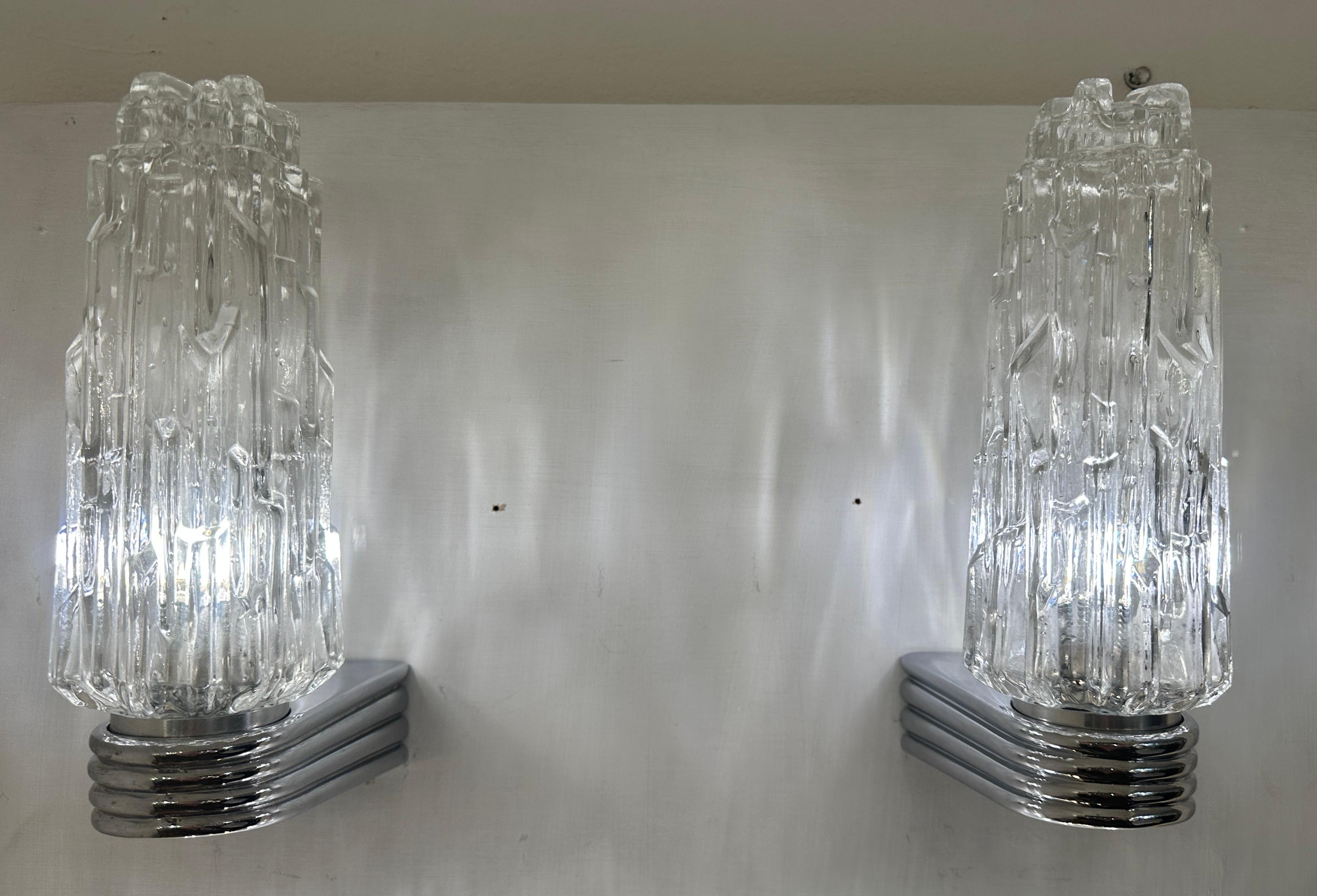 Pareja de apliques o apliques vintage de los años 70 de cristal transparente iceberg y cromo pulido.  Fabricado por Hoffmeister Leuchten en Alemania.  Cada aplique tiene un cristal transparente que apunta hacia arriba.  Las pantallas encajan en el