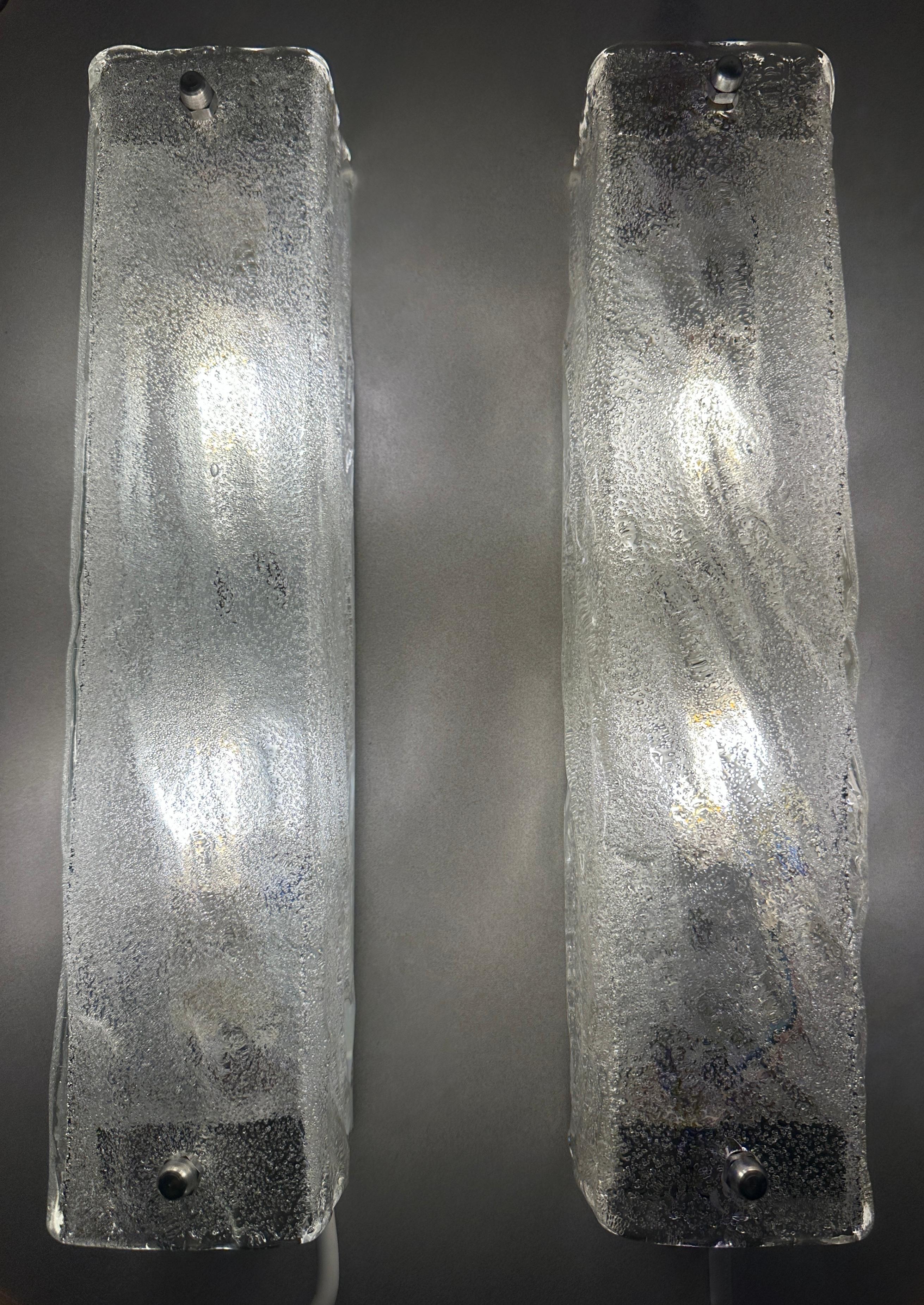 Pareja de apliques o lámparas de pared de cristal esmerilado de la década de 1970, fabricados por el prestigioso fabricante alemán de lámparas Kaiser Leuchten. El cristal rectangular de textura gruesa se atornilla a un marco metálico blanco que se