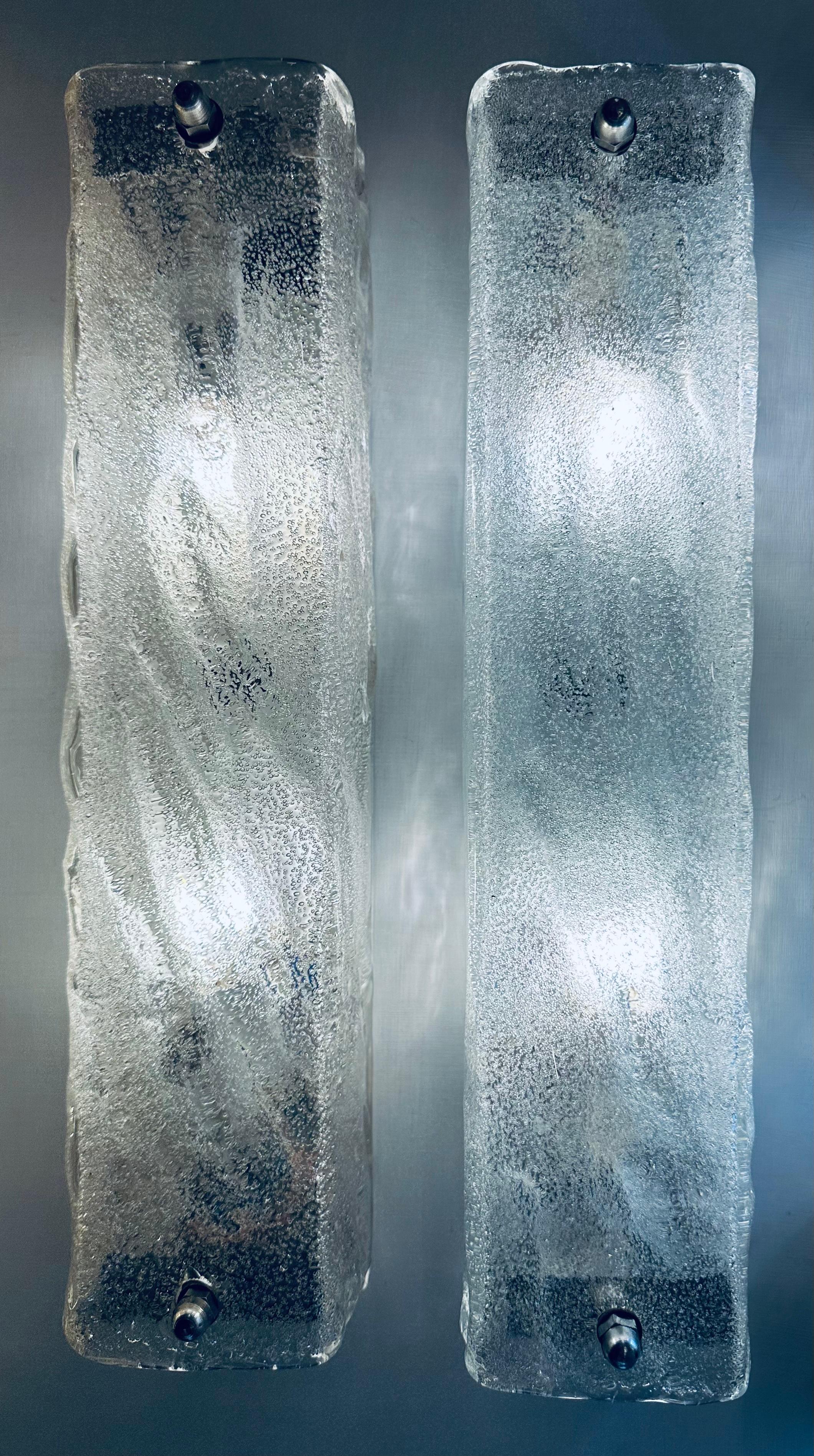 Pair of 1970s frosted iced-glass wall sconces or wall lights manufactured by the upmarket German light manufacturer Kaiser Leuchten. The rectangular thick textured glass screws on to a white metal frame which is easily screwed into the wall. The