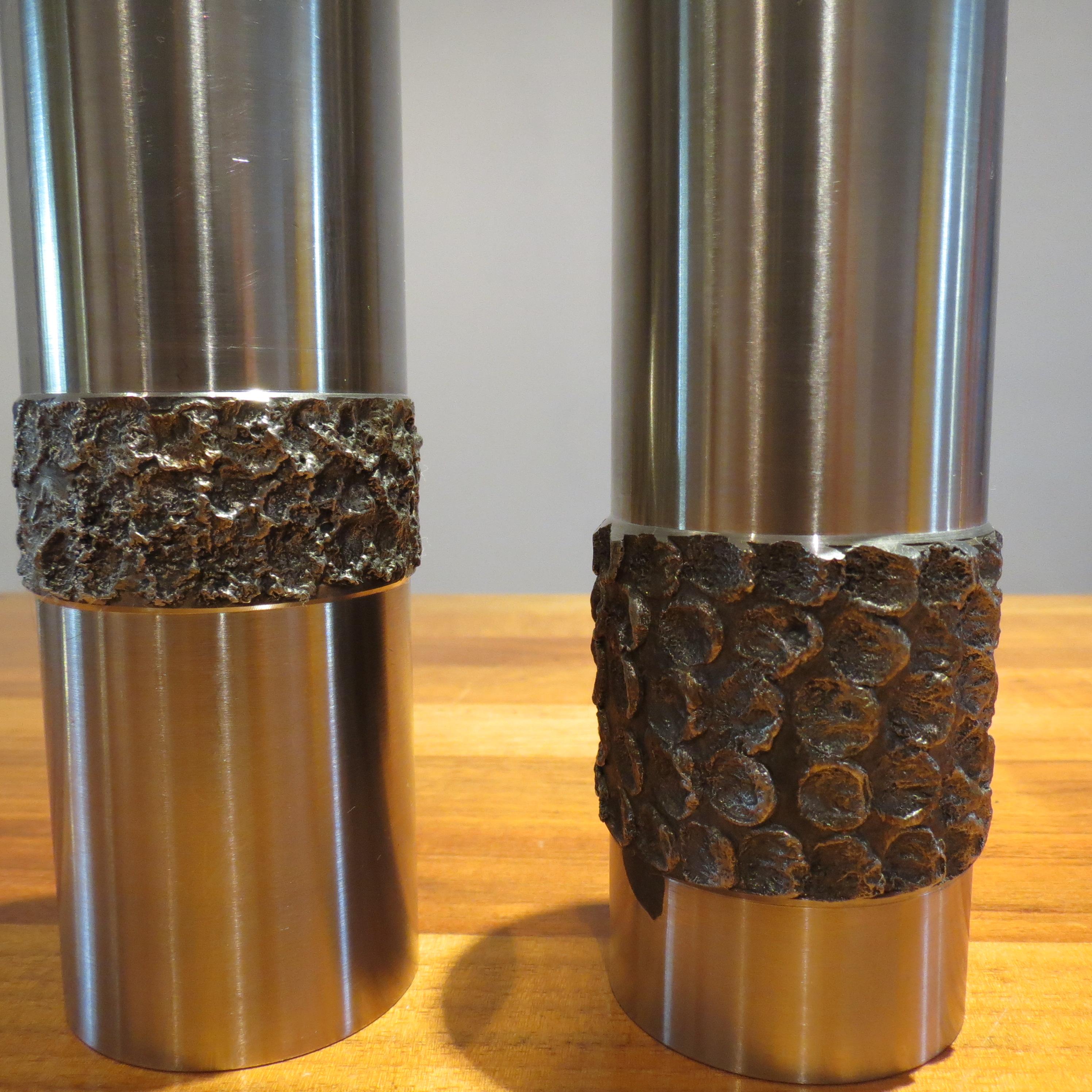 Pair of stainless steel vases in Brutalist form from the 1970s.
Hand produced in Germany, turned stainless steel with decorative pattern. Very much in the style of Stuart Devlin. Heavy good quality piece, could also be used as candleholders. 
