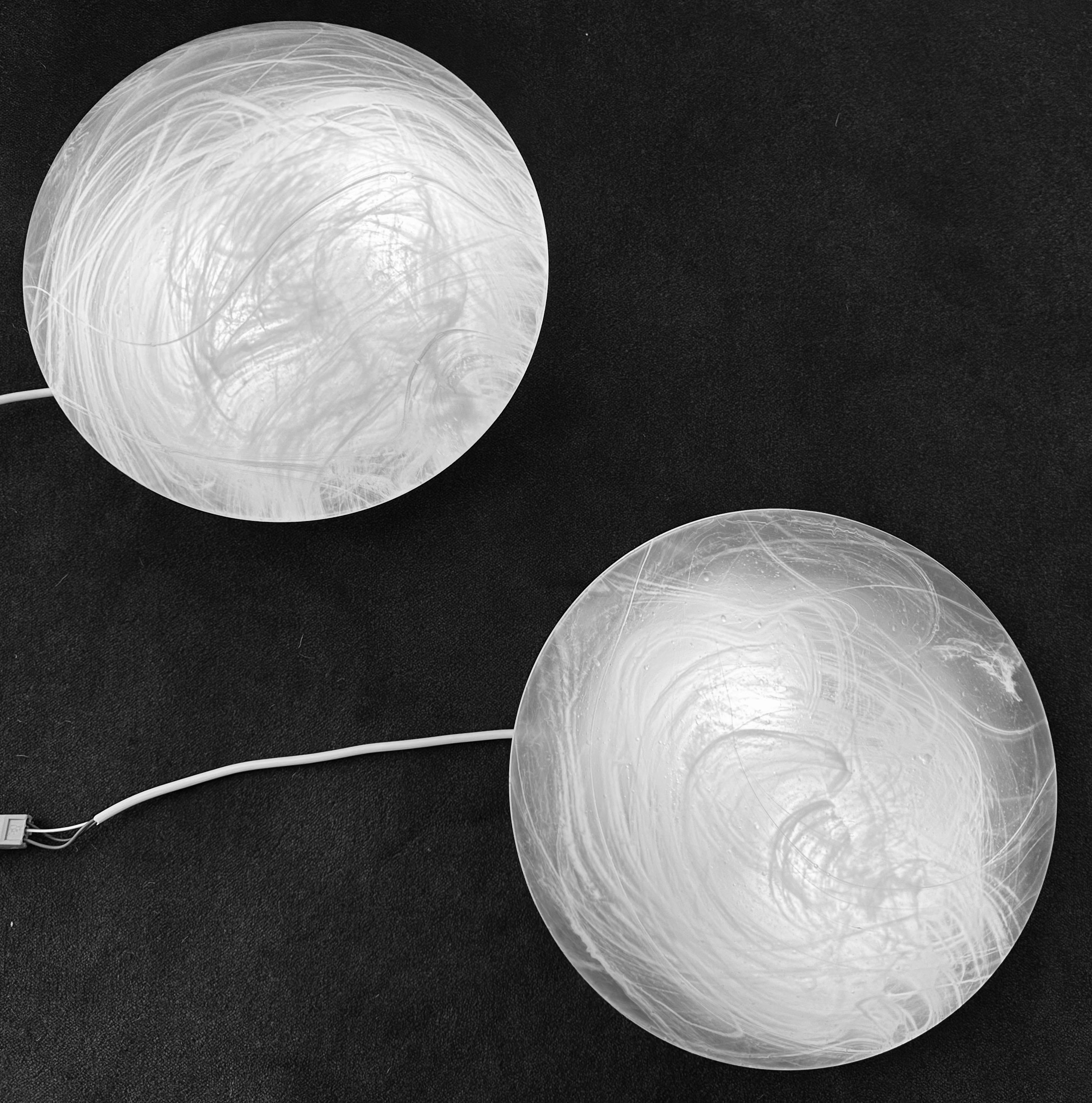 An unusual pair of 1970s German Peill & Putzler space-age frosted glass with a swirled cloud-like pattern wall lights/sconces or flush mount ceiling lights. The frosted glass round shades slot onto the white lacquered metal bulb holders and turns