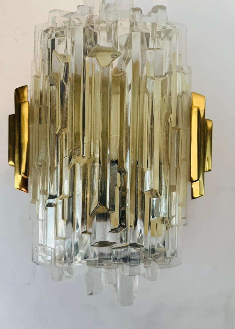 Pair of luxurious 1970s High Style wall lights composed of golden brass fittings and ice crystal glass shades. Newly rewired. Candelabra sockets.