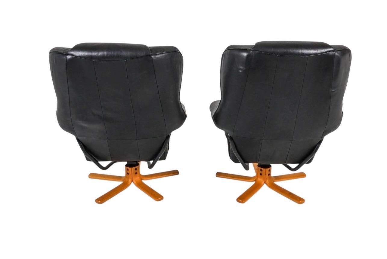 Questa coppia di poltrone reclinabili vintage di Hjellegjerde Mobler incarna il meglio del design scandinavo degli anni '70. Rivestite in pelle nera con basi in legno curvato scolpite, queste sedie offrono una silhouette sorprendente con un perfetto