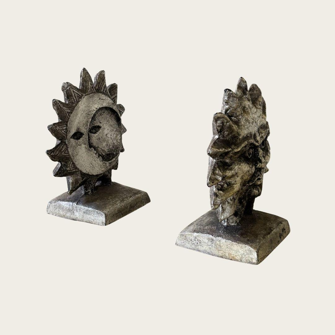 Fermalibri scultorei con sole e luna sui lati opposti. Ferro battuto argentato. Firmato e datato dall'artista. Il prezzo si riferisce alla coppia.