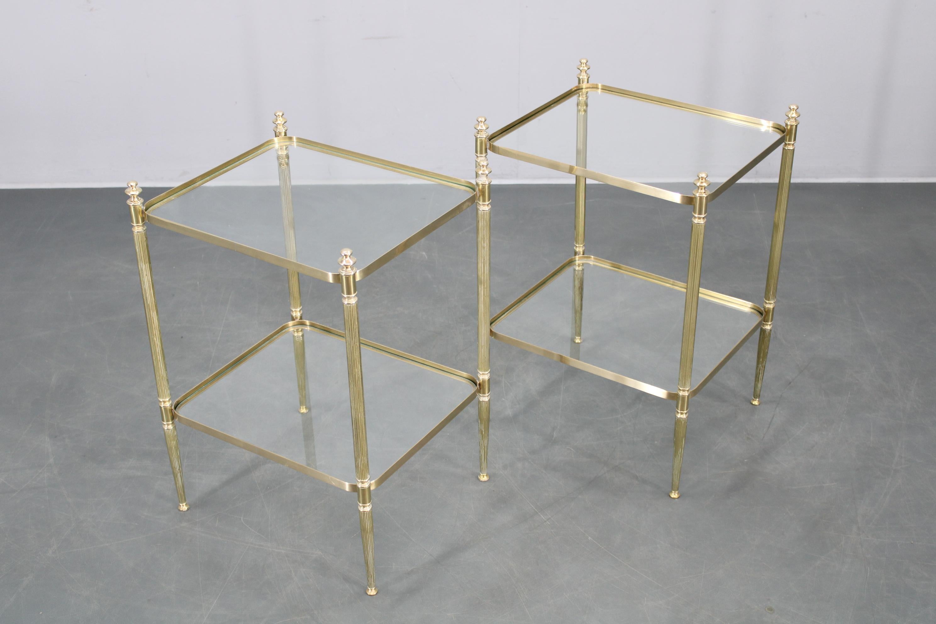 Raffiniertes Paar Beistelltische aus Italien aus den 1970er Jahren mit einem Gestell aus poliertem Messing und Platten und Ablagen aus Klarglas. Diese eleganten Tische heben neoklassische Details und zeitlose Linien hervor und eignen sich perfekt
